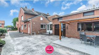 Betaalbare gezinswoning met charmante tuin in rustige woonwijk<br /><br />Deze verzorgde halfopen bebouwing aan de Burgemeester Martinstraat 6 in Lanaken is gelegen in een rustige woonwijk, op een steenworp van het centrum van Lanaken. Het prachtige domein Pietersheim en het Nationaal Park Hoge Kempen bevinden zich op wandelafstand. Ook scholen, buurtwinkels en openbaar vervoer zijn vlot bereikbaar. Bovendien sta je op slechts 5 autominuten in het bruisende centrum van Maastricht.<br /><br />De woning is gelegen op een perceel van 686 m² en beschikt over een onderhoudsvriendelijke tuin met een overdekt terras en heeft verschillende plekjes om te genieten. Met een bewoonbare oppervlakte van maar liefst 200 m² biedt deze woning bijzonder veel ruimte en mogelijkheden. Een extra troef is het afzonderlijke garagegebouw met automatische sectionaalpoort, ideaal voor het parkeren van de wagen, fietsen of als extra opslagruimte.<br /><br />De lichtrijke woonkamer beschikt over een open haard en is ingedeeld in een salon en een zithoek. Met dubbele beglazing en raampartijen geniet deze ruimte van een aangename natuurlijke lichtinval. Vanuit de zithoek is er rechtstreeks toegang tot de veranda, waardoor binnen- en buitenleven mooi in elkaar overvloeien.<br /><br />Verder bevindt zich op het gelijkvloers een badkamer met inloopdouche en lavabomeubel. Daarnaast is er een praktische wasplaats voorzien met aansluiting voor wasmachine en droogkast, evenals een afzonderlijk toilet.<br /><br />De keuken is functioneel ingericht en uitgerust met een kookplaat, inbouwkoelkast en elektrische oven van AEG. Aansluitend bevindt zich de eetkamer, die in directe verbinding staat met de leefruimte. <br /><br />Op de eerste verdieping bevinden zich drie slaapkamers van circa 10 m², 12 m² en 14 m², en een vierde kamer van 7 m² die perfect kan dienen als kinderkamer, bureau of hobbyruimte. Deze volledige verdieping is afgewerkt met laminaat.<br /><br />De tweede verdieping is bereikbaar via een vaste houten trap en biedt nog heel wat extra mogelijkheden. Deze ruimte kan naar eigen smaak worden ingericht als bijkomende slaapkamer, hobbykamer, bureau of polyvalente ruimte.<br /><br />Daarnaast beschikt de woning over een kelder van 22 m², ideaal als voorraadruimte, berging of extra opslagplaats.<br /><br />Extra troeven van deze woning<br />•Bewoonbare oppervlakte van 200 m²<br />•Rustige ligging nabij Pietersheim en het Nationaal Park Hoge Kempen<br />•Onderhoudsvriendelijke tuin met overdekt terras<br />•Afzonderlijk garagegebouw met automatische sectionaalpoort<br />•Tweede verdieping met uitbreidingsmogelijkheden<br />•Voorzien van rolluiken<br />•Praktische kelder van 22 m²<br /><br />Op zoek naar een ruime gezinswoning met tuin, garagegebouw en extra mogelijkheden op een rustige maar centrale locatie? Contacteer ons via 089 390 990 of info@immofair.be en kom deze woning samen met ons ontdekken.