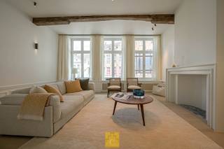 Op één van de meest iconische en begeerde locaties in het hart van Brugge — het idyllische Sint-Jansplein, vlak bij de Markt, de schouwburg en de wereldberoemde reien — bevindt zich dit uitzonderlijk diephuis, een architecturale parel die zowel geschiedenis ademt als hedendaags comfort biedt.  Dit authentieke pand met drie traveeën en drie bouwlagen onder zadeldak is een zeldzame vondst in Brugge’s historisch patrimonium. De gevel draagt de sporen van een rijk verleden, terwijl het interieur volledig werd ondergedompeld in een high-end renovatie die tot in de kleinste details verfijning en kwaliteit uitstraalt. Elk element van deze woning werd met uiterste zorg geselecteerd en gerealiseerd. Denk aan maatwerkmeubilair, fineerafwerkingen, edele materialen, moderne technieken discreet geïntegreerd in de historische context, massieve parketvloeren en hoge balkenlagen, ambachtelijk pleisterwerk dat aansluit bij het authentieke karakter.. De leefruimtes baden in natuurlijk licht en bieden uitzicht op het levendige plein én een verrassend rustige terrastuin achteraan. De keuken is een statement van luxe en functionaliteit, perfect voor zowel intiem thuisgebruik als stijlvolle ontvangst. De slaapkamers en ensuite badkamers bieden hotelwaardige comfort, waarbij ook hier enkel gebruik werd gemaakt van topmaterialen en tijdloos design. Dit pand is geen klassiek woonhuis — het is een statement, een stuk erfgoed, een levensstijl. Een thuis voor wie het buitengewone waardeert, voor wie kwaliteit en karakter vooropstaan. Indeling : gelijkvloers : royale inkom met dubbele glazen deur, traphal, vestiaire en gastentoilet. Aan de kant van het plein een keuken met een zelden gezien afwerking (oa eiland in Chambolle natuursteen, toestellen van V-Zug, ingebouwde zitbank in notelaar). Een verborgen deur leidt naar de eetkamer, die uitgeeft op de patio (zuid-west oriëntatie).Verder op het gelijkvloers een handige technische ruimte en een bureau, ruimtes die ook perfect zouden kunnen dienen als slaapkamer en badkamer. Op de 1<sup>ste</sup> verdieping is er aan de pleinkant een subliem salon met 3 hoge dubbele ramen en een uitzicht om U tegen te zeggen. Opnieuw via een verborgen deur bereiken we de bibliotheek/bar, heel cosy, volledig in notelaar en voorzien van wastafel, vaatwas en koelkast, uitgevend op de knappe en goed bezonde terrastuin. Op de tweede verdieping 2 knappe slaapkamers, beiden met badkamer ensuite en een apart toilet. Via een trap met een leuke twist bereiken we de master suite, met volledige dressing en eigen badkamer met ligbad, dubbele wastafel, toilet en grote inloopdouche (zicht op het Belfort). G-score : A - P-score: A<br /> 