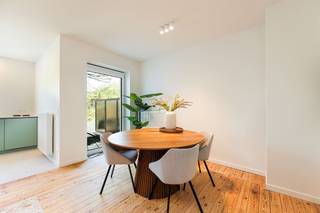 <p><span>Op de eerste verdieping van een kleinschalig gebouw ligt dit volledig gerenoveerde appartement waar rust, licht en verfijning mooi samenkomen. De afwerking is doordacht en warm, met natuurlijke materialen en zachte kleuraccenten die het interieur karakter geven. Een fijne woonplek voor wie houdt van comfort, maar ook oog heeft voor detail.</span></p><p><span>Licht, ruimte en een rustige flow</span></p><p><span>De inkomhal verbindt alle ruimtes en zet meteen de toon met een mooie houten parketvloer die doorloopt in het appartement. De leefruimte is open en uitnodigend, met voldoende plaats voor een zithoek en eethoek. Grote ramen zorgen voor een aangename lichtinval en versterken het open gevoel doorheen de ruimte.</span></p><p><span>Keuken met karakter</span></p><p><span>De open keuken sluit naadloos aan bij de leefruimte en vormt een echte blikvanger. De matte saliegroene kasten zorgen voor een zachte toets kleur en combineren mooi met het lichte werkblad en de strakke lijnen. Volledig uitgerust en praktisch ingericht, is dit een keuken die even mooi als functioneel is — ideaal voor dagelijks gebruik én gezellige momenten.</span></p><p><span>Twee slaapkamers en comfortabel sanitair</span></p><p><span>Het appartement beschikt over twee slaapkamers, beide afgewerkt met houten parket en rustig gelegen. De badkamer is strak en hedendaags ingericht met een ruime inloopdouche en dubbele lavabo. Daarnaast is er een apart toilet, wat het comfort alleen maar versterkt.</span></p><p><span>Buiten zitten in het groen</span></p><p><span>Aansluitend aan de leefruimte bevindt zich het terras, perfect georiënteerd op het zuidoosten. Een fijne plek om ’s ochtends van de zon te genieten of even tot rust te komen na een drukke dag, met zicht op het groen rondom.</span></p><p><span>Wonen tussen parken en stad</span></p><p><span>Je woont hier in een rustige, residentiële buurt in Deurne, op wandelafstand van het Boekenbergpark, Boelaerpark en het Rivierenhof. Tegelijk zijn winkels, scholen en openbaar vervoer vlot bereikbaar en ben je snel in het centrum van Antwerpen of op belangrijke invalswegen.</span></p><p><span> </span></p>
