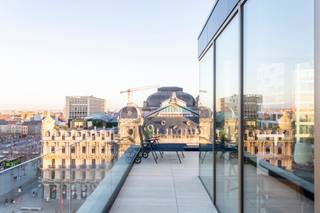 <p>Welkom in dit instapklaar appartement op de vijfde verdieping van een stijlvol gerenoveerd gebouw met slechts acht wooneenheden. Het pand onderging recent een totaalrenovatie en combineert hedendaags comfort met verfijnde afwerking. Het absolute hoogtepunt? Het adembenemende uitzicht op het Operagebouw van Antwerpen.</p>
<p>De leefruimte baadt in natuurlijk licht dankzij de grote raampartijen. De moderne open keuken sluit naadloos aan op de woonkamer en vormt de perfecte plek voor gezellige diners. Warme eikenkleuren en een elegante visgraatparket zorgen voor een tijdloze en klassevolle uitstraling. Vanuit de woonkamer stap je zo op het charmante terrasje, waar je kan genieten van één van de mooiste panorama’s van de stad.</p>
<p>Het appartement beschikt over twee volwaardige slaapkamers, ideaal voor een gezin, logeerkamer of home office. De stijlvolle badkamer is uitgerust met een inloopdouche en hoogwaardige inbouwkranen, waar design en comfort elkaar ontmoeten.</p>
<p>Een unieke kans om te wonen in een exclusief, volledig vernieuwd gebouw, midden in het bruisende hart van Antwerpen, met een uitzicht dat je elke dag opnieuw weet te betoveren. Interesse? Contacteer LISTED vandaag nog: +32 3 283 51 51.</p>