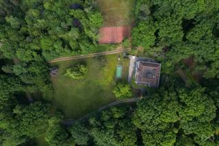 <p>Tussen de glooiende velden van Boutersem, op een domein van maar liefst <strong>5,5 hectare</strong>, ligt een woning die zelden op de markt komt, en nog zeldzamer is in karakter: <strong>Huize Balder</strong>. Deze exclusieve villa combineert een rijke geschiedenis met een unieke architectuur en uitzonderlijke privacy. Het is een plek waar verleden en toekomst elkaar ontmoeten in een oase van rust, stijl en mogelijkheden.<br /><br /><strong>Huize Balder werd gebouwd in het interbellum door Alphonse Cappuyns</strong>, een briljante chemicus en pionier in de industriële productie van citroenzuur. Als oprichter van La Citrique Belge werkte Cappuyns nauw samen met Italiaanse partners – een band die zijn weerslag vond in de bouw van deze villa. <strong>Italiaanse (Siciliaanse) elementen zoals zuilengalerijen, arcades en mediterrane terrassen</strong> werden harmonieus geïntegreerd in een verder klassiek Belgische woningstijl. Het resultaat is een architecturaal geheel dat warmte, verfijning en wereldse allure uitstraalt.<br /><br />Met een <strong>bewoonbare oppervlakte van ca. 976 m²</strong> biedt de villa ruimte in overvloed. Er zijn <strong>10 slaapkamers</strong>, meerdere badkamers, een monumentale traphal met authentieke details en lichte leefruimtes met zicht op het parkdomein. Buiten vindt u een <strong>verwarmd zwembad</strong>, <strong>drie tennisvelden</strong> en meerdere terrassen die uitkijken op het omliggende groen. Alles is omgeven door een <strong>volledig afgeschermd domein</strong>, bereikbaar via een private oprijlaan, waardoor <strong>absolute privacy gegarandeerd is</strong>.<br /><br /><span>Ook qua ligging scoort deze eigendom uitzonderlijk goed.</span><span> Een </span><strong>strategische uitvalsbasis tussen Leuven en Tienen</strong><span>, met </span><strong>uitstekende verbindingen naar Brussel via de E40</strong><span><strong>.</strong> <br /><br /></span>Deze uitzonderlijke eigendom biedt <strong>veel meer dan alleen woonruimte</strong>. Dankzij haar schaal en indeling is Huize Balder perfect geschikt voor wie een <strong>familiedomein, praktijkruimte, retreatlocatie of zelfs een kleinschalige hospitality-ontwikkeling</strong> voor ogen heeft. Denk aan een exclusieve B&B, kunstenaarsresidentie, of een inspirerende thuis voor wie wonen en werken wil combineren. De mogelijkheden zijn legio, en de structuur van het pand leent zich uitstekend tot verdere verfijning.<br /><br />Maar Huize Balder is vooral ook een plek met een ziel. <strong>Een woning met een naam, een verhaal en een verleden.</strong> In de vorige eeuw fungeerde het domein als ontspanningsoord voor sportieve en culturele weekends. Kinderen speelden in de bossen, volwassenen genoten van rust, fitness en gezamenlijke diners op de terrassen. Vandaag is het tijd voor een nieuw hoofdstuk – geschreven door wie nu op zoek is naar iets écht bijzonders.<br /><br />Neem contact met ons op voor een bezoek of meer informatie. We laten u graag kennismaken met een plek die u nooit meer vergeet.<br /><br />AANDELENOVERDRACHT MOGELIJK!</p>