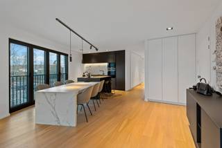 ENERGIEZUINING APPARTEMENT MET LOFT GEVOEL<br /><br />Leefruimte met open keuken, vestiairekasten, vast tv-meubel<br />Keuken met vaatwasser, koelkast, microgolfoven, heteluchtoven, inductie vuur, ingebouwde dampkap, bovenblad uit Dekton, kookeiland, en ontbijthoek.<br />Nachthal op parket met bureau en ingemaakte kasten, gastentoilet en handenwasser.<br />Wasplaats op parket met aansluiting voor wasmachine &amp; droogkast.<br />Hoofdslaapkamer op parket met aanpalende dressing en hoofdbadkamer met ligbad, inloopdouche, dubbel lavabomeubel en toilet.<br />2de slaapkamer op parket met aanpalende 2de badkamer en inloopdouche met enkel lavabomeubel.<br />Zuidwest terras op keramische tegel, gedeeltelijk overdekt, met verlichting.<br />Inclusief garagebox met automatische poort, verlichting en wateraansluitingen (Pidpa &amp; regenwaterput).<br /><br />BIJZONDERHEDEN<br />Volledig opgeschilderd, Lift, Nico home domoticasyteem, allarminstallatie, sunscreens, 6 zonnepanelen, cv op gas, vloerverwarming, dubbele beglazing in aluminium (Reynaers Aluminium) met vliegenhorren &amp; jaloezieën, magneetdeuren, videofoon.<br /><br /><b>POSITIEVE ASPECTEN<br /></b>Loft gevoel<br />Zéér veel lichtinval<br />Gunstige EPC-score<br />Luxueuze afwerking<br />Zuidwest terras zonder niveau verschil<br />Doodlopende straat met zeer veel parkeergelegenheid<br />Op wandelafstand van winkels, scholen &amp; openbaar vervoer