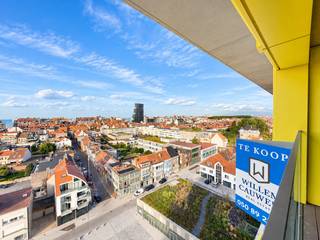 In het iconisch nieuwbouwproject "Hoost" verkopen wij dit splinternieuw appartement, voorzien van 2 kamers en een groot inpandig terras.<br />Vanop de 9de verdieping hebt u een panoramisch zicht over de omgeving en ervaart u een absoluut kustgevoel. Een terras dat profiteert van de opkomende en ondergaande zon, en dit in een volledig nieuw appartement, geheel energiezuinig en conform met de laatste technieken.<br /><br />Indeling: inkomhal, een brede leefruimte met een tijdloze open keuken, een schitterende eetplaats en een zitruimte met toegang naar een mooi inpandig terras.<br />Naast de keuken nog een praktische berging/wasplaats. Verder nog 2 kamers (waarvan 1 met dressing), een apart toilet en een hedendaagse badkamer met inloopdouche.<br /><br />Verkoop onder btw-stelsel.<br /><br />Voor meer informatie of een vrijblijvend bezoek:<br />Contacteer Willem Cauwels op tel. 050/89.27.70.