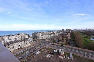 Op de <strong>12e verdieping</strong> van een recente residentie in Oostende bevindt zich dit <strong>volledig afgewerkte nieuwbouwappartement</strong> met een <strong>ruim zonneterras</strong> en <strong>adembenemende uitzichten</strong> over zee, de golf en de Wellingtonrenbaan.<br />Bij het binnenkomen wordt u verwelkomd door een <strong>ruime inkomhal</strong> die toegang biedt tot de lichtrijke leefruimte. De <strong>woonkamer met eetplaats</strong> geniet van grote raampartijen die zorgen voor een overvloed aan natuurlijk licht en een prachtig panoramisch zicht.<br />Via het <strong>schuifraam</strong> bereikt u het <strong>ruime zonneterras</strong>, waar u in alle rust kunt genieten van zowel het <strong>zeezicht</strong> als het <strong>groene uitzicht op de golf</strong> — een ideale plek om te ontspannen en te genieten van de unieke sfeer van de kust.<br />Het systeem gebruikt een geothermische warmtepomp die warmte uit de ondergrond haalt via ingegraven collectoren.<br />Het appartement omvat verder:
<ul>
	<li><span>Een <strong>praktische bergruimte</strong></span></li>
	<li><span>Een <strong>slaapkamer met prachtig uitzicht</strong></span></li>
	<li><span>Een <strong>moderne badkamer</strong> met <strong>douche en lavabo</strong></span></li>
	<li><span>Een <strong>slaaphoek</strong> met ruimte voor een <strong>stapelbed</strong>, ideaal voor extra gasten of kinderen</span></li>
</ul>
Extra troeven:

<ul>
	<li><span><strong>Mogelijkheid tot aankoop van een staanplaats</strong> in het gebouw</span></li>
	<li><span><strong>Fietsenberging aanwezig</strong></span></li>
	<li><span><strong>Volledig instapklaar</strong> en afgewerkt met kwalitatieve materialen</span></li>
</ul>
Dankzij de <strong>uitstekende ligging</strong> nabij het strand, winkels en openbaar vervoer is dit appartement perfect geschikt als <strong>vaste woonst, tweede verblijf</strong> of <strong>investering aan zee</strong>.<br />📞 <strong>Interesse om dit uniek gelegen appartement met zonneterras te ontdekken?</strong><br />Contacteer <strong>Nicolas</strong> via <strong>0495/50.69.20</strong> of mail naar <strong>nicolas@jolieinvest.be</strong> voor meer informatie of een bezoek.<br /><br /> 