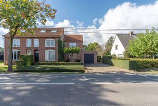 <p><strong>Een thuis waar jaren '30-charme en modern comfort elkaar vinden.</strong></p>
<p>Bent u op zoek naar een instapklare woning met karakter, ruimte en een heerlijke tuin vol privacy? Dan mag deze parel op een centrale locatie nabij het centrum van Poppel en de Nederlandse grens zeker niet ontbreken op uw bezichtigingslijst.</p>
<p>Deze woning, oorspronkelijk gebouwd in de jaren '30, werd in 1989 volledig verbouwd en uitgebreid.</p>
<p><strong>Gelijkvloers<br /></strong>Via de voordeur komt u binnen in een praktische inkomhal met inbouwkast. Maar de woning wordt voornamelijk via de achterzijde betreden, waar u meteen wordt verwelkomd door de mooie, groene achtertuin. De lichtrijke achterinkomhal baadt dankzij de raampartijen in het natuurlijk licht, waarbij het zonwerende glas zorgt voor een aangenaam binnenklimaat en een fraaie verbinding met de tuin.</p>
<p>De woonkamer met houten parketvloer en sfeervolle spotverlichting ademt warmte en gezelligheid uit, terwijl het elektrisch rolluik aan de voorzijde extra comfort en veiligheid biedt.</p>
<p>De landelijke keuken, met praktische tegelvloer, vormt een fijne en gezellige plek in de woning. Volop ruimte voor een eettafel, een bewust verlaagd kookgedeelte voor comfortabel koken, en een verrijdbaar keukeneiland dat moeiteloos plaatsmaakt wanneer u gasten ontvangt voor een etentje, kerstdiner of feestje. De keuken is bovendien uitgerust met kwalitatieve Miele-apparatuur (vaatwasser, oven, inductiekookplaat en cooker), vijf jaar geleden vernieuwd.</p>
<p>Verder op het gelijkvloers: een gastentoilet, een handige wasplaats met inbouwkasten en aansluitingen, en een badkamer (gerenoveerd 12 jaar geleden) met inloopdouche, wastafel met inbouwkasten en zelfs een ingebouwde plafondradio voor die extra touch. Via een vlizotrap vanuit de wasplaats bereikt u een eerste bergzolder.</p>
<p><strong>Verdieping<br /></strong>Deze verdieping biedt drie ruime slaapkamers, waaronder een master bedroom met airconditioning. Één slaapkamer geeft via een vlizotrap toegang tot een tweede bergzolder. Een apart toilet op de verdieping maakt het geheel helemaal af.</p>
<p><strong>Buitenruimte<br /></strong>Het absolute pluspunt van deze woning is de tuin. Op het terras kunt u heerlijk genieten van de schaduw en verkoeling onder de dakplatanen. Daarnaast biedt de tuin ook volop lekkers uit eigen omgeving, met rode bessen, witte frambozen en bramen.</p>
<p>Tegen de woning aan bevindt zich een extra berging met aansluitende overkapping. De ideale plek om te zitten en te genieten, met een prachtig overzicht over het volledige perceel. Liefhebbers van tuinieren komen helemaal aan hun trekken dankzij de eigen moestuin, en achteraan het perceel vindt u een kippenhok met tuinhuisje voor extra bergruimte.<br /><br /><strong></strong>Met een oprit voor maar liefst vier auto's en een garage met elektrische poort (plaats voor één wagen plus extra opslag), is parkeren hier geen enkel probleem.</p>
<p><strong>Een instapklare woning met karakter, comfort en een heerlijke groene tuin. Een plek waar u zich meteen thuis zult voelen.</strong></p>
<p>Wilt u deze woning zelf ervaren? Neem gerust contact met ons op voor een bezichtiging.<br /><br />Vermelde oppervlakten zijn indicatief. Oppervlakte conform EPC.</p>