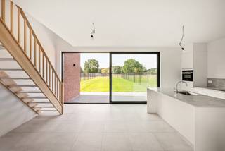Cette maison neuve à moitié ouverte est située à la campagne à seulement 5 km du centre de Heist-op-den-Berg et de Wiekevorst, avec une vue dégagée sur les champs à l'arrière.<br /><br />Grâce à son architecture moderne et à ses valeurs écologiques, ces maisons ont beaucoup de caractère et de confort.<br /><br />La maison a une surface habitable de 167 m² et est déjà entièrement finie. Elle comprend un hall d'entrée avec toilettes invités, un salon, une cuisine ouverte, un débarras, 3 chambres, 1 salle de bain et un garage.<br /><br />Détails:<br />- maisons déjà finies<br />- label BEN-20<br />- panneaux solaires (5 panneaux de 410 Wp)<br />- chauffage par pompe à chaleur air/eau, chauffage par le sol.<br />- le prix n'inclut pas les frais de notaire, la TVA (6%) sur la part de construction (319 000 EUR) et les droits d'enregistrement (12%) sur la part du terrain (130 000 EUR)<br />- le prix n'inclut pas les raccordements aux services publics<br />- plan de distribution disponible sur demande !<br /><br />Appelez maintenant notre agent immobilier pour prendre rendez-vous sur place !