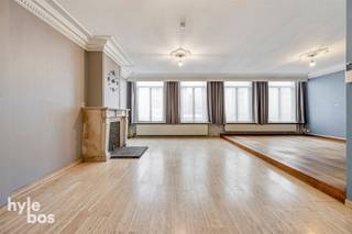 <p><span>Dit centraal gelegen en uitzonderlijk ruime bovenhuis combineert comfortabel wonen met uitgebreide professionele mogelijkheden. Via de lift bereikt u de inkomhal op de eerste verdieping. Het bovenhuis beschikt over een lichtrijke en royale leefruimte welke meteen opvalt door haar aangename volume en overvloedige lichtinval. De ingerichte keuken is voorzien van alle comfort met toestellen (keramisch kookvuur, vaatwasmachine en dampkap). Verder beschikt het pand over een apart toilet, drie volwaardige slaapkamers en een ruime badkamer uitgerust met ligbad, douche, dubbele lavabo en toilet. Het gebouw is voorzien van een lift die beide verdiepingen bedient en wordt verwarmd via centrale verwarming op aardgas. Op het gelijkvloers bevinden zich een individuele garage en een groot magazijn van circa 350 m², terwijl er in de achterbouw op de eerste verdieping nog een bijkomend ruim magazijn aanwezig is van circa 250m². Een ideale eigendom voor wie wonen en werken wenst te combineren op een vlot bereikbare locatie. </span></p>