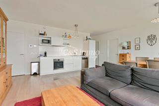 Cet appartement prêt à emménager (environ 94 m²) est situé au 12e étage avec vue sur l'eau, dans le quartier animé d'Eilandje, près du Montevideo et à quelques minutes à vélo du centre-ville. Hall d'entrée avec accès au débarras et aux toilettes séparées avec lavabo. Grand salon et salle à manger (environ 43 m²) avec parquet, grandes baies vitrées et accès à la terrasse (environ 9 m²). Depuis le salon et la terrasse, vous pouvez profiter en toute tranquillité d'une vue unique sur l'Escaut et les docks. La cuisine ouverte de qualité, avec sol carrelé, est équipée d'un four, d'une plaque de cuisson vitrocéramique, d'un réfrigérateur avec compartiment congélateur et d'un lave-vaisselle. Chambre principale (environ 15 m²) et deuxième chambre (environ 11 m²) également avec parquet. Cette dernière peut également être aménagée en bureau, salle de loisirs ou chambre d'enfant. Au bout du couloir se trouve une salle de bains équipée avec carrelage, baignoire avec douche, radiateur sèche-serviettes et double meuble de salle de bains. Cave. Place de parking pour 35 000 €. Emplacement idéal avec tous les commerces et restaurants à proximité.