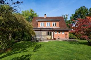 <p><strong>Karaktervolle vrijstaande woning met 3 slaapkamers, veranda en prachtig</strong> <strong>aangelegde tuin op toplocatie aan de Kalmthoutse Heide</strong></p>
<p>Deze solide en karaktervolle gezinswoning bevindt zich op een bijzonder gegeerde locatie, aan de ingang<strong> van de Kalmthoutse Heide</strong>. De woning beschikt over aangename leefruimtes, 3 slaapkamers, een veranda, een inpandige garage en een <strong>prachtig aangelegde, zonnige tuin</strong>. Dankzij de degelijke basis en de mogelijkheden tot opfrissing vormt dit een mooie opportuniteit om een woning volledig naar eigen smaak in te richten.</p>
<p><strong>Gelijkvloerse verdieping</strong></p>
<ul>
<li>Ruime <strong>inkomhal</strong> met vestiaire onder de trap</li>
<li>Lichtrijke <strong>woon- en eetkamer</strong> met parketvloer, sfeervolle houthaard uit Franse zandsteen en grote raampartijen met zicht op het groen</li>
<li>Aansluitende <strong>veranda</strong> met uitzicht op de tuin, ideaal als extra zit- of ontspanningsruimte</li>
<li>Afgesloten <strong>keuken</strong> met keramische kookplaat, oven, dampkap, koelkast en dubbele spoelbak</li>
<li>Vanuit de keuken toegang tot de inkomhal en de achterliggende <strong>wasplaats</strong></li>
<li>Apart toilet</li>
<li>Rechtstreekse toegang tot de <strong>inpandige garage</strong> met manuele garagepoort</li>
<li>Toegang tot de <strong>kelder</strong></li>
</ul>
<p><strong>Eerste verdieping</strong></p>
<ul>
<li><strong>3 slaapkamers</strong>, voorzien van parketvloer</li>
<li><strong>Badkamer</strong> met douche, lavabo en toilet</li>
<li>Ruime overloop met houten trapafwerking</li>
</ul>
<p><strong>Zolder en kelder</strong></p>
<ul>
<li><strong>Bergzolder</strong> bereikbaar via een vlizotrap</li>
<li>Woning gedeeltelijk onderkelderd</li>
</ul>
<p><strong>Tuin en buitenruimte</strong></p>
<ul>
<li><strong>Prachtig aangelegde en zeer zonnige tuin</strong> met volwassen bomen en gevarieerde beplanting</li>
<li>Aangenaam terras met betonklinkers, aansluitend op de veranda</li>
<li><strong>Groene omgeving</strong> met veel privacy</li>
<li><strong>Oprit</strong> en een <strong>inpandige garage</strong> voor 1 wagen</li>
</ul>
<p><strong>Bijzonderheden</strong></p>
<ul>
<li><strong>Solide woning</strong> met een degelijke betonnen draagstructuur</li>
<li><strong>3 slaapkamers</strong> en aangename leefruimtes</li>
<li>Veranda met houten ramen en recent vernieuwde zonwering aan de zijkant en op het dak</li>
<li>PVC-ramen met <strong>dubbele beglazing</strong></li>
<li>Rolluiken, grotendeels manueel en elektrisch in de woonkamer</li>
<li>Centrale verwarming op gas</li>
<li><strong>Mooie mogelijkheden tot opfrissing en modernisering</strong></li>
<li>Uitzonderlijke ligging op wandelafstand van de Kalmthoutse Heide</li>
</ul>
<p><strong>Ligging</strong></p>
<p>Gelegen in Kalmthout, <strong>aan de prachtige Kalmthoutse Heide</strong>. Een ideale locatie voor liefhebbers van natuur, rust en wandelen. Zowel het centrum van Kalmthout als Heide bevinden zich in de nabijheid, met scholen, winkels en andere dagelijkse voorzieningen binnen handbereik.</p>
<p><strong>Een karaktervolle gezinswoning met een prachtige tuin en bijzonder veel mogelijkheden, op een toplocatie aan de Kalmthoutse Heide.<br /></strong></p>
<p>Bewoonbare opp. 193 m² ref.: bruto vloeropp. EPC-certificaat</p>
<p><strong> </strong></p>