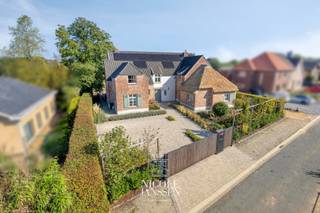 Deze uitzonderlijke woning combineert comfort, ruimte en veelzijdigheid op een unieke manier. Gelegen in een rustige, mooie straat in het groene Dorne-Opoeteren, biedt deze eigendom niet alleen een stijlvolle hoofdwoning, maar ook een volledig ingerichte inpandige zorgwoning — ideaal voor kangoeroewonen of praktijk aan huis. Dankzij de kwalitatieve afwerking, moderne technieken en prachtig aangelegde tuin met zwembad is dit een plek waar wonen en genieten naadloos samenkomen.<br /><br />=> Ligging<br />Rustig gelegen in een verzorgde straat in Dorne-Opoeteren, geniet je hier van een groene en landelijke woonomgeving met veel privacy. <br />De ligging combineert het beste van twee werelden: enerzijds de rust en natuur van het Maaslandse landschap, anderzijds een vlotte verbinding naar Maaseik, Genk en omliggende gemeenten. <br />Ideaal voor wie comfortabel wil wonen in een aangename buurt, met de nodige voorzieningen en dagelijkse faciliteiten binnen bereik.<br /><br />=> Gelijkvloers hoofdwoning<br />- Inkomhal met vestiaire en gastentoilet<br />- Lichtrijke leefruimte met inbouwhaard en grote raampartijen <br />- De keuken werd in 2025 volledig gerenoveerd met hoogwaardig materiaal en bevat een inductiekookplaat met geïntegreerde afzuigkap (in centrum), een combi oven/micro, oven/stoomoven, Siemens vaatwasser en een Cooker kraan (met 100° en bruisopties)<br />- Tweede zitkamer met pelletkachel en aansluitende bureauruimte<br /><br />=> Gelijkvloerse zorgwoning<br />- Aparte inkomhal<br />- Leefruimte met kitchenette<br />- Slaapkamer<br />- Badkamer met douche, toilet en wastafel<br /><br />=> Eerste verdieping<br />- Overloop met apart toilet <br />- Ouderlijke slaapkamer met dressing en ensuite badkamer voorzien van douche, jacuzzi, toilet en dubbele wastafel<br />- Drie bijkomende slaapkamers met parketvloer<br />- Tweede badkamer met dubbele lavabo en douche<br /><br />=> Zolder<br />- Bereikbaar via uitschuifbare trap <br /><br />=> Kelder<br />- Volledig onderkelderd met o.a. C.V.-ruimte, ingerichte wijnkelder, wasplaats en twee bergingen<br />- Buitentrap naar de tuin<br /><br />=> Tuin<br />- Fraai aangelegde en volledig omheinde tuin met automatische toegangspoort<br />- Dubbele vrijstaande garage<br />- Voldoende parking op eigen terrein<br />- Betegeld terras<br />- Zwembad met warmtepomp en liner <br />- Grasrobot<br />- Praktische achtertoegang via servitudeweg