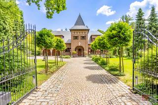 Ruime vrijstaande villa gebouwd in 1989, gelegen op een royaal perceel van 3049m² met een woonoppervlakte van 365m², deze karaktervolle villa ademt charme, klasse en ruimte. Met zijn kasteelachtige uitstraling en perfect onderhouden tuin straalt de woning van buitenaf pure elegantie uit. Binnen wacht een interieur dat even verzorgd is: een stijlvolle mix van klassieke elementen, warme materialen en een overvloed aan natuurlijk licht. De woonkamer is rijkelijk afgewerkt met sierlijsten, een statige haard en grote raampartijen met zicht op het groen. De keuken is volledig ingericht en sluit aan bij de huiselijke sfeer, terwijl de tuinkamer en het overdekte terras uitnodigen tot genieten in alle seizoenen. Op de verdieping bieden de slaapkamers volop ruimte met een grote bijhorende badkamer. Deze woning is ideaal voor wie op zoek is naar comfort, rust en een exclusieve uitstraling in een groene omgeving.<br /><br />Deze woning bevindt zich in een rustige en residentiële buurt, ideaal voor wie comfort en sereniteit zoekt. Op wandelafstand liggen scholen, supermarkten en ambachtelijke bakkers, wat het dagelijkse leven vergemakkelijkt. De nabijheid van het Nationaal Park Hoge Kempen biedt volop mogelijkheden voor wandel- en fietstochten in de natuur. Ook het winkelcentrum M2 en Maasmechelen Village zijn vlot bereikbaar met de auto. De E314 ligt in de directe omgeving, wat zorgt voor een snelle verbinding naar Genk, Hasselt en Nederland. Openbaar vervoer is eveneens goed toegankelijk. Hier woon je op een plek waar rust, natuur en bereikbaarheid perfect samenkomen.<br /><br />Bezichtig deze woning ook digitaal en 'loop' zelf door de woning. Kijk daarvoor op onze website of via: <br />my.matterport.com/show/?m=FqE5Ua9ZWBc<br /><br />INDELING<br /><br />Gelijkvloers:<br /><br />- Inkomhal met een houten trap vervaardigd uit Olmenhout (een bijzondere houtsoort), uitgerust met een alarmsysteem en parlofoon;<br />- Woonkamer afgewerkt met een travertijnvloer, een gashaard met afstandsbediening (Barabas), coax-aansluiting voor televisie en granieten vensterbanken in het hele vertrek;<br />- Volledig ingerichte keuken met een keramische kookplaat (4-pits Miele), vaatwasser, combi-magnetron (AEG), afzuigkap en een friteuse combi-set (Miele);<br />- Praktische, betegelde bijkeuken met aansluitingen voor wasmachine, spoel- en afgietbak, maatwerkkasten en verwarming;<br />- Lichtrijke tuinkamer (met airco) die alle comfort biedt om het hele jaar door van de tuin te genieten;<br />- Gastentoilet (Geberit) met arduinen lavabo.<br /><br />1e verdieping: <br /><br />- Slaapkamer 1 is afgewerkt met een parketvloer en beschikt over een ensuite dressing met maatwerkkasten;<br />- Badkamer met inloopdouche, dubbele wastafel met spiegelkast, toilet (Sphinx), bidet (Frederich Gröhe), ligbad met jets en thermostatische kraan, elektrische handdoekradiator en tegelvloer;<br />- Slaapkamer 2, gelegen aan de voorzijde onder de toren, beschikt over een bergzolder en is afgewerkt met een vloerkleed;<br />- Slaapkamer 3 is zeer lichtrijk en voorzien van een houten vloer;<br />- Slaapkamer 4, aan de achterzijde van de woning, beschikt over ingebouwde wandkasten op maat;<br />- Alle ramen op de bovenverdieping zijn voorzien van een alarmsysteem.<br /><br />Zolder:<br /><br />- Ruime zolder voorzien van CV ketel met bijhorende technieken (Buderus Logalux S160, Buderus Logamax plus GB162-45BE en bijhorend expansievat).<br /><br />Kelder:<br /><br />- Grote kelder die volledig betegeld werd, ideaal als hobbyruimte met eigen invullen, voorzien van verwarming, systeemplafond en kruipruimte.<br /> <br />Tuin:<br /><br />- Zuidwest georiënteerde tuin;<br />- Arduinen terras met overkapping;<br />- Vijver met siervissen en houten brugje;<br />- 26 zonnepanelen van ieder 305 watt;<br />- Buitenkraan met grondwaterpomp, tevens werd er ook een irrigatiesysteem geïnstalleerd met volautomatisch systeem (Rainbird computer);<br />- Tuinhuis met elektriciteit, water en afvoer;<br />- Fruitbomen (perzik, kersen, peren en appel);<br />- Grote kasseien oprijlaan, tevens voorzien van sierhekwerk met afstandsbediening.<br /><br />Bijzonderheden:<br /><br />- Voor de ramen werd gebruikgemaakt van de duurzame en exclusieve houtsoort Marbou;<br />- 2 septische putten, voorzieningen voor riolering zijn reeds getroffen;<br />- De leien zijn Spaanse natuurleien van 1989;<br />- Elektrische screens in de tuinkamer;<br />- De buitenmuren zijn uitgevoerd met  2 spouwen met er tussen een isolatie steen, totale dikte   34  cm;<br />- De binnenste spouw is voorzien van lagen folie om de meter zodat de lucht blijft stilstaan (hogere isolatie  waarde);<br />- De woonkamer is evenals  keuken en tuinkamer voorzien van vloerverwarming als basis verwarming met tevens  radiatoren als  aanvulling;<br />- Daarnaast is de woonkomen voorzien van afzuig systeem hetwelk in de zomermaanden kan dienen voor topkoeling.<br /><br />Energieprestatie en binnenklimaat (EPB-EPC)<br />Certificaat beschikbaar: Ja<br />EPC certificaatnummer: 20250318-0003554918-RES-1<br />Berekende energiescore : (kWh/m²):  215 (label C)<br />Het certificaat is geldig tot en met: 18/03/2035<br />Electrische installatie: in aanvraag<br /><br />Informatie stedenbouwkundige voorschriften:<br />Stedenbouwkundige vergunning: in aanvraag<br />Meest recente bestemming: woonpark<br />Dagvaarding uitgebracht: in aanvraag<br />VOORKOOPRECHT OP DIT GOED: neen <br />VERKAVELINGSVERGUNNING: neen<br />WATERGEVOELIG OPENRUIMTEGEBIED: neen<br /><br />Overstromingsgevoelige gebieden: <br />Perceelscore of P-score : A<br />Gebouwenscore of G-score: A<br />Ligging in Signaalgebied: neen<br />Ligging in afgebakende oeverzone of afgebakend overstromingsgebied: neen<br /><br />A:geen overstroming gemodelleerd B: kleine kans op overstromingen onder klimaatverandering C: kleine kans op overstromingen D: middelgrote kans op overstromingen<br /><br />Beschermd erfgoed<br />GEINVENTARISEERD ERFGOED: neen<br />BESCHERMD ONROEREND ERFGOED: neen