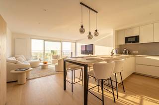 Op een uitzonderlijke toplocatie, op de hoek van de Zeedijk en de jachthaven van Blankenberge, bevindt zich dit stijlvol en tijdloos gerenoveerde appartement op de achtste verdieping van residentie 'Royale Phare'. Dankzij de unieke ligging geniet u van een adembenemend panoramisch uitzicht over de jachthaven, de duinen, de Noordzee én het hinterland. Vanaf het zonnige terras aan de voorzijde beleeft u elke dag opnieuw een schitterend schouwspel, met de late ochtend-, middag- en avondzon als extra troef.<br /><br />Binnen werd het appartement met oog voor detail en duurzame kwaliteitsmaterialen gerenoveerd. De tijdloze afwerking creëert een elegante en warme uitstraling, waardoor u hier jarenlang zorgeloos kunt genieten. De lichtrijke leefruimte sluit naadloos aan op de open, volledig uitgeruste kwaliteitskeuken, die zowel praktisch als stijlvol werd ingericht en over ruime opbergmogelijkheden beschikt.<br /><br />Via de nachthal bereikt u de smaakvol ingerichte badkamer, voorzien van een ruime inloopdouche, een groot badkamermeubel met enkele wastafel en extra wastafel in de hal voor het gastentoilet. De badkamer bevat ook de aansluitingen voor wasmachine en droogkast. Verder beschikt het appartement over twee volwaardige, lichtrijke slaapkamers waarvan één van beide uitgeeft op een tweede terras aan de achterzijde, waar u in alle rust kunt genieten. Een apart gastentoilet vervolledigt het geheel. Verder is er een fietsenberging op kelderniveau en werden de voor- en achtergevel geheel vernieuwd. <br /><br />Ook op technisch vlak scoort deze eigendom uitstekend, met centrale verwarming op aardgas, een conforme elektrische installatie en een gunstig EPC-label. Dankzij de hoogwaardige renovatie, de uitzonderlijke ligging en het fenomenale uitzicht vormt dit appartement de ideale vaste woonplaats, een luxueus tweede verblijf of een zorgeloze investering. Het meubilair kan desgewenst worden overgenomen, waardoor onmiddellijke ingebruikname of verhuur mogelijk is.<br /><br />