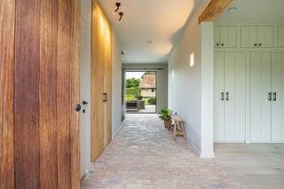 Deze exclusieve villa, gebouwd door het gerenommeerde bouwbedrijf Mattibouw, combineert charme en luxe met hedendaagse technologieën. Er werd gebruik gemaakt van 250 jaar oude derdeling Paepesteen en authentieke tegelpannen. Het indrukwekkend woonvolume en de sublieme afwerking maken dit eigendom uniek.<br /><br />GELIJKVLOERS<br />De inkomhal van 17 m², afgewerkt met Imperial Tiffany’s, straalt grandeur uit en bevat een gastentoilet met handenwasser en ingebouwde vestiairekasten.<br />De woonkamer van 37 m² op brede parketvloeren heeft een ingebouwde haard met warmterecuperatie en een op maat vervaardigd tv-meubel.<br />De eetkamer van 21 m² biedt uitzicht op de aangelegde tuin.<br />De leef-eetkeuken van 49 m² is het hart van de woning. Hier ligt handgetrommelde, gezoete Belgische blauwe hardsteen, gecombineerd met een mezzanine van 15 m² in volle eik.<br />De keuken is uitgerust met een kookeiland en hoogwaardige apparatuur: inductiekookplaat, dubbele oven, twee warmhoudlades, ingebouwde koelkast, vaatwasser van Miele, dampkap, koffiecorner en inbouwcassette. Een schuifraam verbindt de keuken met het terras.<br />De berging van 5 m² op kerkdal biedt extra opslag voor voeding en dranken.<br />De wasplaats van 8 m² met werkblad in blauwe hardsteen is ingericht met inbouwkasten en aansluitingen voor wasmachine en droogkast.<br />De bureauruimte van 27 m² met massieve eiken planken is geschikt om wonen en werken te combineren.<br />Een tweede bureauruimte van 25 m² op parket heeft een kastenwand en wandverlichting.<br /><br />Het terras van 100 m² werd aangelegd in Candela Grey natuursteen en beschikt over een apart toilet met handenwasser.<br />Het overdekt terras van 20 m² op platines is verwarmd.<br />De tuin, aangelegd door Witse’s Tuinen, is een waar kunstwerk.<br />Blikvanger is de natuurlijke zwemvijver met hoogwaterlijn en biologisch filtersysteem.<br />De poolhouse/garage van 44 m² werd in dezelfde afwerkingsgraad gebouwd en is bereikbaar via een aparte oprit in kasseien met automatische poort.<br /><br />1STE VERDIEPING<br />De overloop van 30 m² op parket leidt naar het mastergedeelte, een nachttoilet en meerdere kamers.<br />De hoofdslaapkamer van 22 m² kijkt uit op de tuin en grenst aan een ensuite dressing van 19 m² op parket.<br />De ensuite badkamer van 19 m² op tegel beschikt over ligbad, inloopdouche, dubbel lavabomeubel, spiegel en toilet, afgewerkt met microcement.<br />Een polyvalente ruimte van 53 m² kan gebruikt worden als fitness of worden opgedeeld in kamers.<br />Er zijn twee slaapkamers van elk 14 m² op parket en een tweede badkamer van 6 m² met inloopdouche en lavabomeubel.<br /><br />2DE VERDIEPING<br />Een ruime opbergzolder is bereikbaar via een vlizotrap.<br /><br />ONDERGRONDSE VERDIEPING<br />De kelder van 326 m² is ideaal voor autoliefhebbers of wijnverzamelaars.<br />Er is een wijnkelder van 25 m², opslagruimte met ingemaakte kasten, werkplaats van 34 m² met krachtstroom en een ondergrondse garage van 244 m² met plaats voor zeven wagens.<br /><br />TECHNIEK EN VEILIGHEID<br />Verwarming en koeling via geothermische warmtepomp.<br />Domoticasysteem van Nico Home Control voor aansturing van verlichting, verwarming en gordijnen.<br />Beveiliging met raam- en deurcontacten en warmtecamera’s.<br />Ventilatiesysteem type D.<br />Ramen uit Afrikaans hardhout en aluminium met vierseizoensglas.<br />380V-stroomvoorziening, UTP-aansluitingen in elke ruimte, Daikin-airconditioning.<br />Regenwaterput van 20.000 liter, geboorde waterput van 90 meter diep en automatisch beregeningssysteem.<br /><br />POSITIEVE ASPECTEN<br />EPC-label A<br />100% privacy<br />High-end afwerking<br />Sterk beveiligd<br />Zuid-west georiënteerde tuin<br />Rustige residentiële omgeving<br />Ideale combinatie wonen en werken