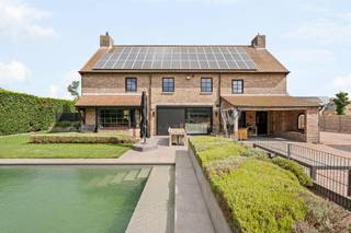Prachtige villa met zicht over weilanden op 1,6 Ha te Lommel<br /><br />Prachtige, exclusieve villa met zicht over weilanden op een ruim perceel van 1,6 Ha. Gelegen in een rustige straat, nabij de Nederlandse grens. Op het gelijkvloers inkomhal met toilet, ruime leefruimte met eetkamer, salon, bureau, ingerichte keuken, wasplaats, toegang kelder en berging. Op de eerste verdieping bevinden zich 4 slaapkamers, 1 badkamer en apart toilet. Vaste trap naar de zolderverdieping met mogelijkheid tot verdere afwerking.<br />Mooie tuin met overdekt terras en zonneterras, zwembad en groot bijgebouw (138m²) met 4 paardenstallen, op een perceel met prachtig zicht over weilanden!<br /><br />Indeling gelijkvloers:<br />Via de inkomhal met gastentoilet heeft u enerzijds toegang tot de woonkamer met bureauruimte en anderzijds tot het keukengedeelte. Deze is zeer ruim opgevat en bestaat uit een lichte eetkamer met prachtig zicht over de tuin en zwembad, een gezellige zitkamer met inbouwcassaette en daarlangs bureauruimte. Vanuit alle leefruimten heeft u een prachtig zicht op de aangelegde tuin met zwembad.<br /><br />De leefruimte sluit naadloos aan op de open luxe keuken voorzien van een inductiekookplaat (SMEG), 3 heteluchtovens, oven, vaatwasser, koelkast en eiland. <br />Tevens is er een ruime en praktische bijkeuken/wasplaats voorzien van maatkasten. <br /><br />Eerste verdieping:<br />De nachthal biedt toegang tot de 4 slaapkamers op deze verdieping. De master-suite is voorzien van airconditioning en ingebouwde kasten. Verder is er nog de 2de, 3de en 4de slaapkamer. De laatste slaapkamer wordt momenteel gebruikt als dressing/berging. De ruime badkamer is voorzien van bad, douche en dubbele wastafel. Apart toilet op de nachthal.<br /><br />Tweede verdieping:<br />Via een vaste trap komen we tot dit volwaardige extra verdiep. Deze ruimte biedt mogelijkheden tot extra slaapkamer(s) en/of hobbyruimte.<br /><br />Bijgebouwen en tuin:<br />De tuin is uitgerust met een gezellig overdekt terras, een zonneterras, een zwembad en een ruim bijgebouw (ca. 138m²). Hierin is deels garage en deels voorzien voor 4 paardenstallen. Verder is er aansluitend aan de tuin een prachtig weiland volledig omheind met kwaliteitsvolle houten omheining, wat zeer veel mogelijkheden biedt voor paarden-en dierenliefhebbers.<br /><br />BIJZONDERHEDEN<br />- Zonnepanelen <br />- Airconditioning <br />- Vloerverwarming<br />- Omheinde weilanden<br />- Bijgebouw met paardenstallen<br />- Natuur achteraan perceel
