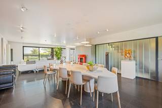 Cette maison surprend dès le premier instant. Derrière la façade discrète se cache une maison spacieuse, moderne et extrêmement pratique où le confort, la fonctionnalité et la qualité de vie sont au centre.<br /><br />En entrant, on remarque immédiatement l'excellente disposition. Au rez-de-chaussée, la maison dispose d'un double garage et d'un espace supplémentaire polyvalent actuellement utilisé comme salle d'exposition, mais pouvant être aménagé en espace de pratique, bureau ou espace de loisirs. Grâce à l'ascenseur, chaque étage est facilement accessible, ce qui rend cette maison particulièrement tournée vers l'avenir.<br /><br />Au rez-de-chaussée, vous trouverez également un sauna et une douche, donnant un accès direct au jardin. Le magnifique jardin arrière est un véritable oasis de verdure et de calme. Vous pourrez profiter d'un bel étang, d'une cabane de jardin pratique et d'une sortie arrière séparée, idéale pour l'entretien du jardin ou le transport de matériel sans devoir passer par la maison.<br /><br />En empruntant l'escalier ou l'ascenseur, vous accédez au premier étage où se trouve le spacieux espace de vie. De grandes fenêtres offrent une abondance de lumière naturelle et une vue magnifique sur le jardin verdoyant. À côté se trouve la cuisine semi-ouverte entièrement équipée, en parfaite harmonie avec le caractère ouvert et accueillant de la maison.<br /><br />La véritable attraction de cet étage est sans aucun doute la terrasse exceptionnellement spacieuse. Vous pourrez profiter de la vue sur le vert en toute intimité, tandis qu'une rampe pratique assure une connexion fluide et directe avec le jardin.<br /><br />Au deuxième étage se trouve la zone de nuit. La spacieuse chambre principale dispose de sa propre salle de bains et dressing, offrant une véritable sensation d'hôtel à la maison. Il y a également deux autres chambres à coucher complètes et une deuxième salle de douche qui complètent le confort pour la famille ou les invités.<br /><br />Le dernier étage est actuellement aménagé en espace de bureau, mais peut facilement être transformé en une chambre supplémentaire, un espace de loisirs ou un espace polyvalent selon vos souhaits.<br /><br />La cave offre également beaucoup d'espace. Vous y trouverez de nombreux espaces de rangement, une salle de sport entièrement équipée et une cave à vin chaleureuse. De plus, cet étage est également accessible par l'ascenseur, ce qui augmente encore la facilité d'utilisation.<br /><br />Enfin, cette maison bénéficie d'un excellent emplacement. L'accessibilité est particulièrement fluide, tandis que dans le jardin arrière, vous pourrez profiter pleinement du calme et de l'intimité, sans être dérangé par la route devant.