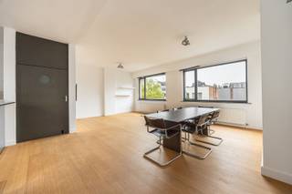 <p>Waar de Kronenburgstraat de Kloosterstraat ontmoet, zit je pal in het centrum van de leukste plek in de Stad. De Scheldekaaien liggen aan het einde van de straat, het KMSKA en Zuidpark zijn vlakbij en voor koffie, lunch, design of een goed glas wijn hoef je eigenlijk nooit ver te wandelen. FUNK in de straat, de Kloosterstraat als buur en de winkels aan je voeten.</p><p>Op de bovenste, derde verdieping vinden we dit bijzonder lichte appartement met twee slaapkamers en twee terrassjes. Geen bovenburen, wel licht langs voor- en achterkant en vooral, midden in de stad.</p><p>Waarom je hier wil wonen<br />•    Bovenste verdieping, zonder bovenburen<br />•    Royale en lichtrijke leefruimte<br />•    Open keuken met bar<br />•    2 volwaardige slaapkamers<br />•    Masterbedroom met ingemaakte kasten<br />•    2 kelderbergingen</p><p>De inkomhal heeft een praktische vestiarekast en gastentoilet.</p><p>Van daaruit bereik je de leefruimte, waar grote ramen aan beide kanten van het gebouw voor bijzonder veel natuurlijk licht zorgen. Zithoek, eetplaats en keuken lopen mooi in elkaar over en creëren één aangename woonruimte.</p><p>De open keuken combineert roestvrij staal met een multiplex werkblad en heeft een fijne bar waar de eerste koffie van de dag minstens zo goed smaakt als op café. Vanuit de keuken stap je rechtstreeks het eerste terrasje op. Tussen keuken en zithoek zit nog een handige berging.</p><p>Achteraan bevinden zich twee volwaardige slaapkamers, de tweede ook ruim genoeg voor een tweepersoonsbed. De masterbedroom beschikt over een volledige wand met ingemaakte kasten.</p><p>De badkamer heeft een dubbele lavabo en ligbad (met douche) en toegang naar het tweede terrasje voor een koffietje voor of na het douchen.</p><p>Ondergronds horen bovendien twee kelderbergingen bij het appartement.</p><p>Interesse? Plan je bezoek via www.sinjoor.be of bel ons op 03 283 05 00.</p>