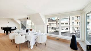 <p><span>Subliem zonnig duplexappartement met ruime terrassen en zijdelings zeezicht, op enkele stappen van de Zeedijk in Knokke.</span></p>
<p><span>Via de inkomhal met gastentoilet, vestiaire en ruime wasplaats komt u in de zeer lichtrijke leefruimte, die rechtstreeks uitgeeft op twee terrassen, respectievelijk zuid- en oostgericht, met zijdelings zeezicht. Dankzij de grote en talrijke raampartijen op het zuiden, oosten en westen genieten de woonkamer, eetplaats, zithoek, keuken en bureau van een uitzonderlijke lichtinval en veel zon.</span></p>
<p><span>De ruime, zonnige zithoek beschikt over een ingebouwde gashaard en tal van maatkasten. Door de raampartijen op zowel het oosten als het zuidwesten baadt deze ruimte in het licht.</span></p>
<p><span>De prachtige, open keuken is zeer kwalitatief afgewerkt in marmer en voorzien van Miele-toestellen, een gezellig eiland met barkrukken en twee grote ingemaakte Amerikaanse koelkasten. De keuken geeft rechtstreeks toegang tot een ruim, zuidwestgericht terras. Aansluitend bevindt zich een ruime bureauruimte met veel maatkasten, eveneens uitgevend op het zuidgerichte terras.</span></p>
<p><span>Via de prachtige trap bereikt u de verdieping.</span></p>
<p><span>De ruime masterbedroom beschikt over tal van eiken maatkasten, een grote tv-wand en een ensuite badkamer met toilet, Italiaanse inloopdouche en wastafel, volledig afgewerkt in prachtige mortex. De tweede volwaardige slaapkamer beschikt over een tweepersoonsbed en mooie eiken maatkasten. De derde slaapkamer is ingericht met een ingemaakt stapelbed, een afzonderlijk eenpersoonsbed en een ensuite badkamer met inloopdouche, toilet en wastafel in mortexafwerking. Deze slaapkamer kan ook als volwaardige slaapkamer ingericht worden met een dubbel bed.</span></p>
<p><span>Privatieve kelder aanwezig in het gebouw. Mogelijkheid tot aankoop van twee garageboxen in het gebouw.</span></p>
<p><span>Superlatieven schieten tekort om dit prachtige appartement te omschrijven. Absoluut een bezoek waard.</span></p>