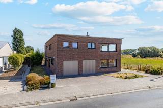 Bent u op zoek naar een zeer ruime woning met uitzonderlijk veel mogelijkheden? Dan is deze eigendom zeker het ontdekken waard.Deze ruime woning is momenteel verdeeld in twee volwaardige wooneenheden, waarbij zowel het gelijkvloers als de eerste verdieping beschikt over een eigen keuken en badkamer. Hierdoor is de woning bijzonder geschikt voor kangoeroewonen, een groot gezin, dubbele bewoning, wonen en werken of als investering.Het gelijkvloers biedt maar liefst 184 m² en beschikt over 3 slaapkamers, een keuken en een badkamer. (EPC D - 20250808-0003661125-RES-1 - 348 kWh/ (m² jaar)) Ook de eerste verdieping beschikt over 3 slaapkamers, een eigen keuken en badkamer, waardoor beide verdiepingen afzonderlijk kunnen functioneren. (EPC F - 20250808-0003661154-RES-1 - 824 kWh/ (m² jaar))Buiten geniet u van een ruime tuin met een groot tuinhuis, ideaal voor extra opslagruimte, hobby's of andere doeleinden. Een absolute blikvanger is het dakterras, vanwaar u kunt genieten van een uitgestrekt en prachtig uitzicht over de omliggende velden.Dankzij de royale oppervlaktes, de twee afzonderlijke wooneenheden en de landelijke ligging biedt deze woning tal van mogelijkheden voor de toekomst.Een unieke eigendom voor wie op zoek is naar ruimte, rust en flexibiliteit. Een bezoek is zeker de moeite waard om het volledige potentieel van deze woning te ontdekken.Voor meer informatie of een bezoek contacteert u Timothy van Immo Zone op 0474/ 41. 28. 40.