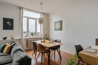 <p><strong>Wonen in geliefd 2018, met de stad vlakbij en toch dat heerlijke gevoel van ruimte? Dat kan in de Lange Leemstraat. Deze buurt combineert een aangename, residentiële sfeer met een centrale ligging, en ook de tramhalte vind je hier voor de deur. Handig als je de stad in wil, zonder dat je daarvoor eerst een halve expeditie moet ondernemen. Op de achtste verdieping van het gebouw wacht hier een charmant éénslaapkamerappartement van 72 m². En het eerste wat hier opvalt? Het licht. En daarna waarschijnlijk het uitzicht. Vanuit élke kamer kijk je ver uit over Antwerpen. Zo'n zicht waar je gerust elke dag opnieuw even voor naar het raam wandelt. Benieuwd? Kom binnen…</strong></p><p> </p><p><strong>Binnenkomen met licht en ruimte</strong></p><p> </p><p>De leefruimte is open en groot en krijgt dankzij de hoge ligging bijzonder veel daglicht binnen. De warme vloer doet de rest: geen kille bedoening hier, maar een gezellige basis waar je meteen een thuisgevoel van krijgt. De ruimte laat zich makkelijk invullen met een gezellige zithoek en eetplek, terwijl het uitzicht ondertussen rustig zijn werk doet. Want geef toe: een woonkamer met zo'n panorama heeft eigenlijk niet veel extra nodig.</p><p> </p><p><strong>Een keuken met karakter</strong></p><p> </p><p>De keuken heeft alles mee om er een gezellige plek van te maken. De houten frontjes zorgen voor een warme uitstraling en het prachtige tegelvloertje geeft de keuken net dat beetje extra karakter. En praktisch is ze ook: naast de keuken vind je een handige opbergruimte. Een kleine schatkamer voor alles wat je liever niet permanent in het zicht hebt. Van voorraad tot huishoudspullen: hier kan je heel wat kwijt.</p><p> </p><p><strong>Slaapkamer met zicht</strong></p><p> </p><p>Ook in de slaapkamer hoef je het uitzicht niet op te geven. De hoge ligging zorgt ervoor dat Antwerpen ook hier voor je raam komt piepen. Een fijne plek om de dag te beginnen én af te sluiten.</p><p> </p><p><strong>Badkamer waar alles gewoon past</strong></p><p> </p><p>De badkamer is verrassend ruim en praktisch ingericht. Je hebt er een bad met douche, een lavabo en een toilet. Ook de aansluiting voor de wasmachine is hier voorzien. Alles wat nodig is, dus, zonder dat er op comfort werd ingeboet.</p><p> </p><p><strong>En dan is er nog de zolder</strong></p><p> </p><p>Alsof het appartement zelf nog niet genoeg ruimte biedt, krijg je er bovenop ook een privatieve zolderberging. Die bevindt zich op de negende verdieping en is een bijzonder fijne extra voor wie graag wat meer stockage achter de hand heeft. Daarnaast komt deze stek ook nog met een privatieve kelderberging én een fietsenberging waar je makkelijk je fietsen kan stallen. Handig!</p><p> </p><p><strong>Een appartement met karakter</strong></p><p> </p><p>Dit is geen dertien-in-een-dozijn appartement. De warme vloer, houten keukenfrontjes, het mooie keukenvloertje, de royale hoeveelheid daglicht en vooral dat indrukwekkende uitzicht geven het geheel een charmante, warme uitstraling. Een fijne plek voor wie graag centraal woont, houdt van licht en ruimte - en elke dag wil genieten van Antwerpen van bovenaf.</p><p> </p><p><strong>Verliefd? Antwerpen@ugly.be</strong></p><p> </p>