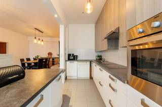 <p><span>Vous recherchez un appartement spacieux et baigné de lumière, juste à la périphérie de la ville ? Vous êtes alors à la bonne adresse. Cet appartement allie confort et solidité et dispose de nombreux équipements supplémentaires agré’. Citons notamment la climatisation’s et les volets roulants automatiques, tous deux facilement contrôlables à distance. Un logement lumineux à l’ambiance agréable où vous vous sentirez immédiatement chez vous.</span></p><p><span> </span></p><p><span>Situé dans un immeuble résidentiel bien entretenu, cet appartement se trouve au rez-de-chaussée. La porte d’entrée sécurisée donne accès à un hall d’entrée spacieux doté d’un vestiaire pratique, idéal pour ranger manteaux et chaussures. Le parquet chaleureux se prolonge harmonieusement dans le salon et le couloir de nuit, créant d’emblée une ambiance agréable et chaleureuse. L’espace de vie constitue sans aucun doute l’un des atouts majeurs de l’appartement. Grâce à l’ouverture sur la cuisine et aux grandes baies vitrées, cet espace est baigné de lumière naturelle. Le parquet apporte un charme et une chaleur supplémentaires, tandis que la surface d’ s permet d’accueillir sans difficulté un salon confortable et un coin repas, parfaits pour partager un repas convivial ou recevoir des invités.</span></p><p><span> </span></p><p><span>Cuisine ouverte sur le salon</span></p><p><span>Depuis le salon, équipé d’une climatisation réversible, la cuisine se trouve derrière un muret, ce qui permet de dissimuler soigneusement l’espace cuisine et l’évier à la vue de la pièce à vivre. Vous disposez ici de tout le confort nécessaire : une plaque de cuisson vitrocéramique, une hotte aspirante, un double évier, un lave-vaisselle, un réfrigérateur, un congélateur et de très nombreux rangements. Le comptoir de cuisine, très pratique, offre en outre un espace de travail supplémentaire et constitue en même temps l'endroit idéal pour un apéritif convivial. </span></p><p><span> </span></p><p><span>3 chambres à part entière et une buanderie séparée</span></p><p><span>Derrière le salon, vous accédez au couloir menant aux chambres, qui peut être entièrement isolé de l’espace de vie. Cela offre davantage de calme et d’intimité dans la partie nuit. De plus, l’appartement dispose de toilettes séparées pour les invités, ce qui est particulièrement pratique lorsque vous recevez des invités sans avoir à entrer dans la partie nuit. Toutes les pièces sont revêtues d’un sol stratifié facile d’entretien et équipées de volets roulants automatiques, idéaux pour profiter d’un sommeil réparateur en toute tranquillité et dans l’obscurité totale. Deux des chambres ont une superficie équivalente et offrent de nombreuses possibilités. La chambre principale est le joyau de l’espace nuit et, avec sa superficie généreuse de pas moins de 20</span><span>m²</span><span>,</span><span>elle est</span><span> particulièrement spacieuse. Grâce à ses baies vitrées, cette pièce bénéficie d’une lumière naturelle abondante. De plus, la chambre principale est équipée d’un climatiseur pouvant aussi bien refroidir que chauffer, ce qui offre un confort supplémentaire tout au long de l’année.</span></p><p><span>De l'autre côté du couloir menant aux chambres se trouvent la salle de bains et une buanderie séparée, un atout pratique au quotidien. La salle de bains est entièrement carrelée et équipée d’un deuxième WC, d’un radiateur sèche-serviettes et d’un meuble de salle de bains comprenant un lavabo, des meubles de rangement et des armoires à miroirs. Elle dispose également d’une ventilation mécanique pour un climat intérieur optimal. La buanderie séparée dispose de branchements pour une machine à laver et un sèche-linge, ce qui permet d’organiser les tâches ménagères à l’abri des regards.</span></p><p><span> </span></p><p><span>Une vie au vert avec tout à</span><span>proximité<br />Vous vivez ici dans un cadre agréable à Deurne, entouré de beaucoup de verdure. L’Ertbruggebos et le Rivierenhof se trouvent tous deux à proximité. Le Sportoase, situé sur la Ruggeveldlaan, se trouve à proximité et constitue un atout indéniable pour ceux qui aiment se détendre ou faire du sport. Écoles, supermarchés, boulangeries, pharmacies et le centre commercial Wijnegem sont tous situés à proximité. Côté mobilité, vous êtes très bien desservi : les tramways et les bus de l'August Van De Wielelei vous emmènent rapidement en ville, et grâce aux voies d'accès voisines dans toutes les directions, vous pouvez vous déplacer en un clin d'œil.</span></p><p><span> </span></p>