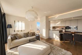 Ontdek dit prachtig afgewerkte hoekappartement op de zesde verdieping in Zeebrugge, waar u geniet van een open, lichtrijke leefruimte en een prachtig zijdelings zeezicht. Dankzij de hoekligging en de grote raampartijen baadt het appartement in natuurlijk licht en ervaart u een aangenaam gevoel van ruimte. De stijlvolle open keuken sluit naadloos aan op de leefruimte en is afgewerkt met kwalitatieve materialen. Vanuit de leefruimte heeft u toegang tot het ruime, zuidgerichte terras, waar u volop kunt genieten van de zon en waar voldoende plaats is voor een comfortabele lounge en eettafel. Daarnaast beschikt het appartement over twee extra balkons met een mooi zicht op het strand en de zee. Er zijn twee ruime slaapkamers, waarvan één volledig is ingericht met drie ingemaakte kasten, geïntegreerde bedden en een bureau, terwijl de tweede een volwaardige en ruime slaapkamer is. Verder beschikt het appartement over een moderne badkamer met douche, een apart toilet en een praktische berging. Bent u op zoek naar een instapklaar appartement met hoogwaardige afwerking, veel lichtinval en een uniek uitzicht over de polders én de zee? Dan is dit de ideale woonst of tweede verblijf. Voor een bezoek of meer informatie kunt u contact opnemen met makelaar Stéphanie via 0472 77 86 60 of stephanie@keyimmo.be. Er is bovendien de mogelijkheid om een garagebox mee aan te kopen