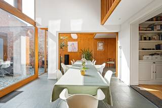 Dit prachtig gerenoveerde herenhuis weet het beste van twee werelden te verenigen: de authentieke charme van weleer, het hedendaags comfort van vandaag en hoogstaande ambachtelijkheid en architectuur. Het resultaat is een karaktervolle woning waar elke ruimte tegelijk warm aanvoelt én functioneel is ingericht.<br />Indeling:<br />Bij binnenkomst word je verwelkomd in een sfeervolle inkomhal die met veel zorg en respect voor het oorspronkelijke karakter werd gerestaureerd. Van hieruit bereik je de multifunctionele eetkamer/atelierruimte: op maat afgewerkt met ingemaakte kasten en een opvallende berkenhouten wand met subtiele koperen accenten. Een perfecte plek om creativiteit te laten stromen, of om jouw mooiste objecten stijlvol uit te stallen. Dankzij de schuifdeuren en moduleerbare wanden deel je deze ruimtes volledig naar wens in.<br />De eetkamer/atelierruimte is rechtstreeks verbonden met de afgewerkte garage. Deze kan uiteraard dienen als klassieke garage, tentoonstellingsruimte of opslagplaats, maar leent zich net zo goed tot een uitbreiding van je atelier- of werkruimte.<br />De authentieke leefruimte, die uitgeeft op de eetkamer, ademt warmte en gezelligheid dankzij de functionele open haard. De ideale plek om tot rust te komen na een drukke dag.<br />De volledig uitgeruste keuken biedt al het hedendaags comfort en kijkt uit op een onderhoudsvriendelijke patio: een stille stadsoase met een bijzonder mooi zicht op de Heilig Hartkerk. Hier vind je bovendien een praktische buitenberging.<br />Op de eerste verdieping kom je via een handige overloop met ingemaakte kasten in de badkamer, waar achter schuifdeuren ook plaats voorzien is voor een wasmachine en droogkast. Verder bevinden zich op deze verdieping de masterbedroom en een extra bureau- of slaapkamer, beide uitgerust met ingemaakte kasten. Een bijkomende werkruimte met grote glaspartijen biedt een prachtig doorkijkje naar het hart van de woning.<br />De tweede verdieping telt nog twee slaapkamers, waarvan één met een charmante mezzanine, aangevuld met een douchekamer en een eigen sauna. Ideaal om een ontspannend moment in te bouwen zonder je huis te verlaten.<br />Kortom, dit herenhuis bruist van karakter en comfort. Authentieke charme, slimme indelingen en een patio die je meteen doet wegdromen. Een huis met een ziel.<br /><br /><br />Buitengewone kenmerken:<br />* Perfect te gebruiken voor gemengd gebruik (kantoor/woning)<br />* woning van de hand van de Turnhoutse architect Jos Verschoren - vooral bekend om zijn ontwerpen in art nouveau-stijl. Met stijl en inzicht gerenoveerd door BLEND architecten.<br />* EPC: label B! Zonneboiler aanwezig, dak vernieuwd in 2002, grondige renovatie woning in 2011-2012<br />* Regenwaterput van 10.000 liter aangesloten op toilet beneden en kraantje buiten. <br />* Zonnewering aan de binnenzijde aanwezig in de badkamer en de eetkamer<br />* Neoclassicistische woning opgenomen in de Vlaamse inventaris bouwkundig erfgoed <br />* Trappenhal en inkomhal zijn gecreëerd door experten van de Brusselse School op basis van speciale marmertechnieken alsook hout-marmer- en steenimitatietechnieken. Recent minitieus gerestaureerd door meester-restaurateurs<br />* Rustige locatie in het midden van de stad, gelegen in een woonerf.
