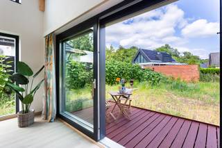 Instapklare en energiezuinige woning met tuin<br /><br />Locatie<br />Gelegen in de Kromstraat in Ranst beschik je over een vlotte verbinding naar het centrum, waar u terecht kunt voor winkels, supermarkten, scholen, horecazaken en andere dagelijkse voorzieningen. Dankzij de verbinding met de E34 en E313 bereikt u Antwerpen en omliggende gemeenten in een mum van tijd. Ook natuurliefhebbers komen hier volop aan hun trekken, met tal van wandel- en fietsroutes in de onmiddellijke omgeving. De ideale locatie voor wie op zoek is naar een perfecte combinatie van ruimte en een uitstekende bereikbaarheid.<br /><br />Beschrijving<br />Deze recente (2025) en energiezuinige prefabwoning combineert een hedendaagse architectuur met een warme, tijdloze uitstraling en een gunstig wooncomfort. Dankzij de afwerking, grote raampartijen en de prachtige vide baadt de woning in natuurlijk licht en geniet u van een aangenaam gevoel van ruimte.Via de inkomhal met ingemaakte vestiairekast betreedt u de woning. De lichtrijke leefruimte vormt zonder twijfel het hart van de woning en wordt gekenmerkt door haar open nok, zichtbare houten draagstructuur en grote schuiframen die een naadloze verbinding creëren met het terras en de tuin. De uitgeruste open keuken beschikt over een strak en tijdloos design met toestellen en voldoende werk- en opbergruimte. Op het gelijkvloers bevinden zich verder een ruime slaapkamer of bureauruimte, een stijlvolle badkamer uitgerust met ligbad en dubbele lavabo, een apart gastentoilet en een praktische berging/technische ruimte. De open trap brengt u naar de verdieping, waar de vide een bijzonder ruimtelijk gevoel creëert en uitkijkt over de leefruimte. Hier bevinden zich nog twee volwaardige slaapkamers, een tweede badkamer met inloopdouche, lavabo en toilet. Ook buiten werd aan comfort gedacht. Via de grote schuiframen bereikt u het zonnige terras dat uitkijkt over de ruime tuin, waar u in alle rust kunt genieten van het groene karakter van de omgeving. De woning beschikt bovendien over een ruime oprit. Op technisch vlak voldoet deze woning aan de hedendaagse verwachtingen. Dankzij de warmtepomp, zonnepanelen, ventilatiesysteem type D, performante isolatie en hoogrendementsbeglazing geniet u van een bijzonder energiezuinige woning met een lage energiefactuur en een uitstekend wooncomfort.<br /><br />Verplichte vermeldingen<br />P-score: D<br />G-score: D<br />Stedenbouwkundige inlichtingen: Vg, Wg, Gvkr, Gvv, Gmo