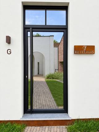 TE HUUR - GENT. Op een rustige en bijzonder charmante ligging aan het Prinsenhofplein in Gent bevindt zich dit uitzonderlijke voormalige ketelhuis, een geklasseerd monument dat met groot respect voor zijn geschiedenis volledig werd gerenoveerd. Achter de karaktervolle gevel schuilt een inspirerende kantooromgeving waarin originele elementen, speelse lijnen en hedendaags comfort harmonieus samenkomen. De hoge plafonds, royale raampartijen en overvloedige lichtinval versterken het open karakter van het gebouw, terwijl kwalitatieve materialen en een verfijnde afwerking voor een tijdloze, representatieve uitstraling zorgen.<br /><br />De inkomhal beschikt over een afzonderlijk toilet en verleent toegang tot de eerste kantoorruimte op het benedenverdiep. Een trap leidt naar de volgende verdieping, waar zich een tweede afzonderlijk toilet, een volledig ingerichte keuken en een stijlvol afgewerkte badkamer bevinden. Via het discrete trapluik bereikt u de bijzondere torenkamer, een intieme en karaktervolle ruimte die de unieke geschiedenis van het gebouw voelbaar maakt. Op de tweede verdieping bevindt zich nog een indrukwekkende werkruimte, badend in natuurlijk licht en met rechtstreekse toegang tot de buitenruimte en het terras.<br /><br />De zwarte stalen draaitrap vormt de absolute blikvanger van het interieur. Haar elegante, ronde lijnen verwijzen subtiel naar de oorspronkelijke vorm van het ketelhuis en verbinden de verschillende verdiepingen op een bijzonder architecturale manier. Airconditioning en een groen dak dragen bij aan het hedendaagse comfort en duurzame karakter van het gebouw.<br /><br />Dit unieke pand is uitermate geschikt voor een kantoor, creatief bureau of onderneming die op zoek is naar een inspirerende en onderscheidende werkomgeving op een rustige locatie in het historische hart van Gent. Twee parkeerplaatsen vervolledigen dit uitzonderlijke huuraanbod.<br />Huurprijs 1950€/maan + maandelijkse algemene kost 150€/maand