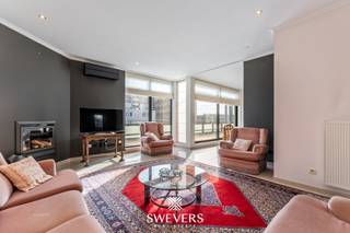 Voor meer info en foto’s, surf naar www.swevers.be – dit instapklare dakappartement aan de Europalaan 59 bus 5.1 in Genk combineert een centrale ligging met een praktische indeling en een aangename woonomgeving. Het appartement bevindt zich in een verzorgd gebouw van 2002 en biedt met een bewoonbare oppervlakte van 123 m² alle ruimte voor comfortabel wonen. Via de inkomhal bereik je de verschillende ruimtes. De leefruimte van 29,14 m² vormt het hart van het appartement en biedt voldoende plaats voor een gezellige zithoek en eethoek. Aansluitend bevindt zich de aparte keuken van 17,08 m², die praktisch is ingericht en beschikt over voldoende werk- en opbergruimte. De slaapkamer van 14,38 m² ligt rustig aan de achterzijde en is ruim genoeg voor een dubbel bed en kastruimte. Bovendien bestaat de mogelijkheid om een tweede slaapkamer te creëren, ideaal als bureau, hobbyruimte of logeerkamer. De badkamer en het aparte toilet bevinden zich centraal in het appartement. Extra troef zijn de twee terrassen met een totale oppervlakte van 32 m². Eén terras sluit aan op de veranda, het andere is bereikbaar vanuit de leefruimte, zodat je op elk moment van de dag van een fijne buitenplek geniet. Verder zijn er een berging in het appartement, een kelderberging en een parkeerplaats inbegrepen. Dankzij de gunstige ligging bevinden winkels, restaurants, openbaar vervoer, scholen en ontspanning zich vlakbij, met ook een vlotte verbinding naar de snelweg. Voor meer informatie, bel 011 255 155. Bron bewoonbare oppervlakte: EPC – verslag.