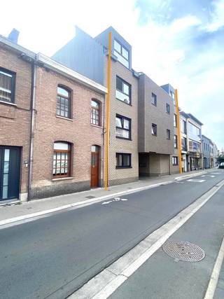 Dit recente en energiezuinige appartement is gelegen op wandelafstand van het OLV - ziekenhuis en op fietsafstand van de Grote Markt van Aalst. Het appartement bevindt zich op de eerste verdieping in een gebouw met lift. Via de inkomhal met apart toilet bereikt men het ruime leefgedeelte met geïnstalleerde keuken voorzien van alle comfort en aanpalende bergruimte. De grote raampartijen in de leefruimte geven rechtstreekse toegang tot het zuidgerichte terras. Verder beschikt het appartement over twee slaapkamers en een badkamer met enkele wastafel en ligbad met douchefunctie. Achter het gebouw is een gemeenschappelijke fietsenberging, vuilnisberging aanwezig alsook een private afgesloten garagebox dewelke kan gehuurd worden voor 75 EUR/maand. Dit ruime moderne appartement is ideaal voor wie op zoel is naar energiezuinigheid in combinatie met kwalitatief wonen. Huurprijs: 875 EUR/maand + 50 EUR/ maand gemeenschappelijke lasten.