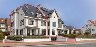 Gelegen langs de Elizabetlaan in het gegeerde Duinbergen bevindt zich villa “Le Hanneton”, een statige halfopen koppelvilla waar karakter en hedendaags comfort mooi samenkomen. Deze recent volledig gerenoveerde woning biedt een bewoonbare oppervlakte van ca. 356 m² op een perceel van 350 m² en beschikt over acht volwaardige slaapkamers en zes bad- en douchekamers. Dankzij deze indeling leent de woning zich zowel als ruime gezinswoning of tweede verblijf aan zee.<br />De leefruimtes zijn aangenaam en lichtrijk, met grote raampartijen die zorgen voor een open gevoel. De open keuken sluit mooi aan op de woonkamer met open haard, een gezellige plek om samen te komen. Alle ruimtes werden praktisch en doordacht ingericht, met aandacht voor comfort.<br />Ook buiten is het aangenaam vertoeven, met een privatief terras waar u in alle rust kan genieten.<br />Een ruime, instapklare villa op wandelafstand van het strand, ideaal voor wie op zoek is naar een comfortabele woning aan zee met veel mogelijkheden.