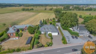 WETTEREN - Deze ruime en kwalitatieve villa, gebouwd met duurzame materialen, combineert een uitstekende bereikbaarheid met een rustige ligging en een blijvend vrij uitzicht over de omliggende weilanden. Gelegen langs de Oosterzelesteenweg, vlak bij de Gentse Steenweg en de oprit van de E40, vormt dit eigendom een ideale uitvalsbasis tussen Wetteren en Geraardsbergen.
Bij het binnenkomen valt meteen de royale inkomhal op, voorzien van vestiaire en gastentoilet. Van hieruit heeft u toegang tot een slaapkamer met badkamer, die ook perfect kan dienen als bureau of praktijkruimte. Aan de andere zijde bevindt zich de lichtrijke leefruimte van 50 m², waar u volop geniet van het zicht op de tuin en de open velden. De aangrenzende keuken, afgewerkt met hoogwaardige materialen, is praktisch ingericht en beschikt over een extra douche, een ruime berging en een wasplaats.
Op de verdieping treft u drie ruime slaapkamers, een bureau dat eenvoudig als extra slaapkamer kan worden ingericht, en een badkamer. Daarnaast is er nog een volwaardige studio die tal van mogelijkheden biedt, van bijkomende kamers tot hobbyruimte of afzonderlijke woonunit.
Ook op praktisch vlak heeft deze villa heel wat troeven. De woning is volledig onderkelderd (135 m²) met diverse stockageruimtes, ideaal voor wie een vrij beroep of commerciële activiteit wil uitoefenen. De inpandige garage van 75 m², met hoge inrijhoogte, is geschikt voor grote voertuigen zoals bestelwagens enz.. In de tuin is er nog een garage aanwezig.
Met een bewoonbare oppervlakte van ca. 280 m², kwalitatieve afwerking en een rustige maar goed bereikbare ligging biedt deze villa uitzonderlijk veel mogelijkheden. Of u nu een ruime gezinswoning zoekt, wonen en werken wil combineren of kangoeroe wonen overweegt: hier gaan stijl, comfort en functionaliteit harmonieus samen.
Aarzel niet en maak snel uw afspraak: 053/60.65.60.