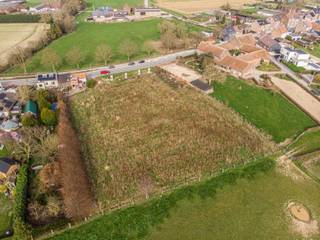 Het perceel bevindt zich in woongebied met landelijk karakter met achteraan agrarisch gebied, waardoor u vanuit de tuin een open zicht heeft op de achterliggende velden. De zuidgerichte tuin zorgt bovendien voor optimale lichtinval en zon gedurende de hele dag.
Volgens de geldende bouwvoorschriften kan er op het gelijkvloers gebouwd worden tot 15 meter diep, en op de verdieping tot 12 meter diep, wat interessante mogelijkheden biedt voor een ruime en comfortabele gezinswoning.
Inplanting van de woning is voorzien op ongeveer 14 meter van de straat.
Deze bouwgrond is gelegen langs de Ninoofsesteenweg in Halle, op een bijzonder praktische locatie tussen het centrum van Halle en Pepingen. Het centrum van Halle bevindt zich op slechts 2,4 km, terwijl het centrum van Pepingen op 3,3 km ligt. Dagelijkse voorzieningen zijn vlakbij: een supermarkt bevindt zich op 2,4 km, een school op 1,8 km en een bushalte op amper 17 meter van het perceel. Het station van Halle ligt op 4 km afstand.
De bouwvoorschriften en alle relevante documenten zijn beschikbaar op kantoor.
Een ideale opportuniteit voor wie landelijk wil wonen met een open zicht, zonder in te boeten aan bereikbaarheid en nabijheid van voorzieningen.