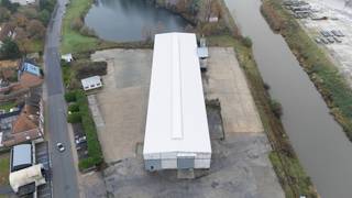 Deze industriële site in Waregem omvat een ruime loods van 2.250 m² (90 m x 25 m) met een vrije hoogte van 9 meter, ideaal voor productie-...