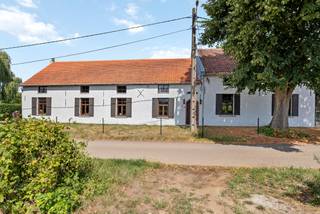 The original farm with stables (1880) has been renovated into the current long farmstead. Many authentic elements have been preserved. Located along a street that leads to the fields, this is an ideal child-friendly location. You can enjoy the perfect balance between privacy and accessibility, with the city center, shops, schools, and public transport less than 4 km away.<br /><br />We enter the house through the huge entrance. The stables and feed troughs have been transformed into a living and dining area. The open space up to the roof ridge provides a lot of natural light. On the right side, the spaces have been preserved, creating 2 lounges and 2 dining areas.<br /><br />The first floor, accessible from two sides, includes several spacious bedrooms, a multipurpose room, and a bathroom. The spacious landing with a library and multiple seating areas is special. There is a connection to the ground floor through the huge loft, which also provides a lot of natural light.<br /><br />Layout:<br />Ground floor: entrance hall with bathroom, on one side a first dining and seating area with stairs to the first floor. On the other side, to the right, the kitchen with a second staircase, a small room, a second dining area, and a second seating area. The outdoor storage is accessible via the covered terrace, where the oil burner and above-ground tanks are located. On the first floor, a landing with loft, hallway with bathroom and a bedroom, multipurpose room with 3 bedrooms, and the second staircase downstairs.<br /><br />Details:<br />-underfloor heating in the living room<br />-central heating with oil (after 2000)