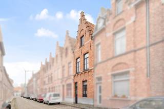 Deze charmante woning biedt een uitstekende ligging in het hart van Brugge, op wandelafstand van het pittoreske Minnewater. De woning heeft een leuke gevel en een karaktervolle uitstraling.

Bij binnenkomst kom je in een ruime inkomhal, die toegang biedt tot de gezellige leefruimte. Aansluitend bevindt zich de keuken, met zicht op een stadstuintje en terras, ideaal om te ontspannen of te genieten van de zon. Op het gelijkvloers is momenteel ook een badkamer voorzien.

Op de eerste verdieping bevinden zich 2 slaapkamers, en via een vaste trap bereik je het tweede verdiep, waar nog eens 2 extra slaapkamers zijn.

De woning is te renoveren, waardoor je de mogelijkheid hebt om ze volledig naar eigen smaak in te richten. Dankzij de topligging en het potentieel van de woning biedt dit een unieke kans voor wie houdt van het bruisende stadsleven én de charme van Brugge wil combineren met persoonlijke touch en renovatiemogelijkheden.

Ben jij op zoek naar een woning in het centrum van Brugge? Contacteer makelaar Stéphanie 0472 77 86 60 of stephanie@keyimmo.be voor een bezoek.