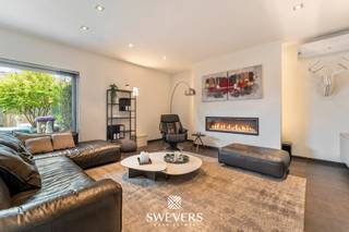 Voor meer info en foto’s, surf naar www.swevers.be– In een rustige en residentiële buurt in Koersel ligt deze uitzonderlijke open bebouwing uit 2004, waar ruimte, comfort en luxe harmonieus samenkomen. De woning is instapklaar en beschikt over een stijlvolle afwerking en een praktische indeling. Op het gelijkvloers verwelkomt een ruime inkomhal met gastentoilet u en leidt naar de gezellige woonkamer van 26,35 m² met gashaard en grote raampartijen die uitkijken op de tuin. Aansluitend bevindt zich de ruime leefkeuken van 29,52 m², ideaal voor gezellige momenten met familie en vrienden, met directe toegang tot de berging. Daarnaast is er een aparte bureauruimte die perfect kan dienen als toekomstige slaapkamer. In combinatie met de nabijgelegen douche en de berging met aansluiting voor wasmachine en droogkast biedt dit de mogelijkheid tot gelijkvloers wonen. Op de eerste verdieping bevinden zich drie slaapkamers van 17,60 m², 11,62 m² en 11,62 m², aangevuld met een aparte dressing en een centraal gelegen badkamer met ligbad, dubbele wastafel en toilet. De woning beschikt bovendien over een bijzonder ruime kelder van 116,77 m², ideaal als opslagruimte, hobbyruimte of werkplaats. Buiten geniet u van een westgericht perceel van 7a 89ca met een prachtig aangelegde tuin, zwembad en luxueus poolhouse met bar, televisie, toilet, infraroodsauna en airconditioning. Het zwembad is via wifi te bedienen en heeft een volledig uitschuifbare overkapping. Verder zijn er een carport van 50 m² met laadpaal, zonnepanelen, een regenwaterput van 10.000 liter en een magazijn met twee sectionale poorten. Winkels en horeca liggen op 450 meter, scholen op 950 meter en de snelweg op 7 km. Voor meer informatie, bel 011 255 155. Bron bewoonbare oppervlakte: EPC – verslag.