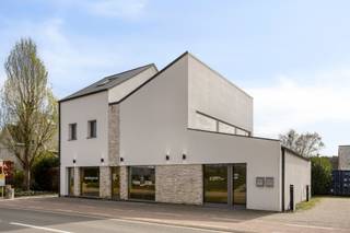 <h2><strong>Moderne, lichtovergoten woon-werk opportuniteit op strategische locatie te Betekom</strong></h2><p>Wonen en werken: twee invullingen onder één dak met tal van voordelen die elkaar versterken. Achter deze moderne gevel schuift namelijk een pand dat uitblinkt in ruimte, licht en flexibiliteit, met een doordachte indeling die zowel jouw privéleven als professionele activiteit laten floreren. Een combinatie om van te dromen, en jij kan er in wonen.</p><p>Thuis wordt je verwelkomd met een open gevoel: een woonkamer met hoge plafonds en een aangename lichtinval. Deze vloeit harmonieus over in de keuken, die volledig is uitgerust en uitkijkt op jouw zalig zonnige, zuidgerichte tuin met modern aangelegd terras en een heerlijk stukje gras dat op een subtiele manier de brug slaat tussen het woon- en werkgedeelte. Gelegen op een perceel van ca. 5 are en waar je in alle rust kan genieten van het buitenleven. Met drie volwaardige slaapkamers, een praktische wasplaats en een ruime badkamer voorzien van zowel bad als inloopdouche, vormt deze woning een ideale thuisbasis voor wie graag ruim en zorgeloos leeft.</p><p>Het handelsgedeelte – via een aparte ingang te betreden – is niet alleen een grote troef, maar ook een ware eye-catcher. Wat je opvalt is de open ruimte, gedefinieerd door een houten structuur, met gepolierde betonvloer en lichtovergoten op beide etages. De combinatie van vloerverwarming met de aanwezigheid van onder meer een keuken en kantoorruimte maken van deze stek een uiterst praktische en veelzijdige werkplek. Of je nu een eigen praktijk wenst te lanceren of een kantoor aan huis wilt organiseren: hier vind je de ruimte én de uitstraling om professioneel te groeien, zonder in te boeten aan privacy. De ligging vertaalt zich bovendien in een uitstekende bereikbaarheid én een sterke commerciële visibiliteit. Tegelijk zijn winkels, bakker en school vlakbij, en steden als Aarschot nabij. </p><p>En ook energetisch sta je sterk: met 25 zonnepanelen en een gunstig EPC zitten deze kosten ook alweer helemaal mee. Als bijkomende opportuniteit kan je de naastgelegen bouwgrond optioneel aankopen. Deze is niet inbegrepen in de vraagprijs en opent perspectieven voor extra parkeergelegenheid, uitbreiding of een invulling op maat van jouw toekomstplannen.</p><p>Kortom, een kantoor waar je met plezier je dagen spendeert, naast een woning die je steevast charmeert. Graag jouw toekomstige woon-werkplek bezoeken? Geef Jes dan snel een seintje, en wij doen de rest.</p><figure><div></div></figure>