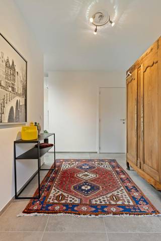 Gelegen aan de Gentsesteenweg te Erondegem (Erpe-Mere) woon je hier bijzonder rustig én bijzonder vlot bereikbaar. De kleinschalige residentie 't Hemelsveld is zowel vooraan als achteraan omgeven door natuurgebied. Alle dagelijkse voorzieningen liggen in de onmiddellijke omgeving: bakker, slager, apotheek, grootwarenhuis, tankstation en horeca. De bushalte bevindt zich op 100m en de oprit van de E40 op 3 km.<br /><br />Deze moderne halfopen bebouwing van 20m diep en 7m breed telt ongeveer 236 m² woonoppervlakte op een perceel van circa 6a84ca, met een zuidgerichte tuin. De woning werd gebouwd volgens de strengste normen inzake isolatie en ventilatie, en dat laat zich voelen: overvloedig licht, een uitgesproken ruimtegevoel en een opvallend akoestisch comfort dankzij de driedubbele beglazing.<br /><br />Op het gelijkvloers brengt de zij-inkom je in een zeer ruime leefruimte van 70m². De open keuken sluit aan op een praktische berging. Verder vind je hier een slaapkamer (of thuisbureau) met eigen badkamer, een apart gastentoilet en een inpandige garage. Het aansluitende terras is voorzien van een buitendouche en de aansluitingen voor een buitenkeuken, ideaal om in de zomermaanden volop buiten te leven.<br /><br />De verdieping telt drie bijkomende slaapkamers, een ruime badkamer, een apart toilet en een extra ruimte die zich uitstekend leent als dressing of bureau. Het hoogtepunt is de rechtstreekse toegang tot het zonneterras op de verdieping, met zicht op de tuin en het bos.<br />Voor de woning bevinden zich er nog 3 autostaanplaatsen.<br /><br />Technisch is deze woning uitzonderlijk doordacht. De combinatie van passiefbouw en zonnepanelen zorgt voor een aanzienlijk lager energieverbruik. Een regenwaterput van 10.000 liter met bijhorend zuiveringssysteem levert bijzonder zacht water, wat het verbruik van leidingwater sterk terugdringt. De driedubbele beglazing is zonwerend uitgevoerd.<br /><br />Troeven:<br />Zuidgerichte tuin van 25 m diep met meerdere terrassen<br />Ruime leefruimte van 70 m² met veel lichtinval<br />Driedubbele zonwerende beglazing <br />Regenwaterput van 10.000 l met zuiveringssysteem<br /><br />Bestuursmaatregelen in het maatregelenregister: nee