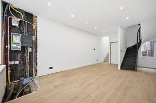 <p><span><span>Midden in het hart van de stad, ligt deze pas vernieuwde woning met wit geschilderde voorgevel en hoge plafonds. Zowel de technieken (elektriciteit en verwarming) als de afwerking zijn nieuw: zwarte alu-ramen met hoogrendementsglas, ingebouwde led-plafondspots, condensatieketel (gas), ventilatieroosters, videofoon, vernieuwd zadeldak en bakgoot, etc. Op het gelijkvloers vangt de living veel licht door grote raampartijen tot plafondhoogte. De keramische tegels met houtmotief zijn geschrankt gelegd. Een achterdeur maakt de kleine koer toegankelijk vanuit de leefruimte. De grote toiletruimte (hangtoilet), werd verfraaid met een lavabomeubel. De keuken bevindt zich op een tussenniveau, dat bereikbaar is via een stevige betontrap met bekleding. Deze ingerichte greeploze eetkeuken met hoogglans, beschrijft een L-vorm en omvat volgende apparaten: koelkast, diepvriezer, oven, kookplaat, dampkap en een vaatwasser. De badkamer boven beschikt over een zwart meubel met ronde spiegel (ingebouwde verlichting), hangtoilet, inloopdouche (regenfunctie) met glazen wand en een witte designradiator. Aan de straatzijde op de eerste verdieping ligt de master bedroom met laminaatvloer en twee hoge ramen. Onder dak neemt de open slaapkamer de hele verdieping in. Het plafond is afgewerkt tot in de nok. De haast perfecte officiële Mobiscore beloopt 9,6 op 10.</span></span></p>