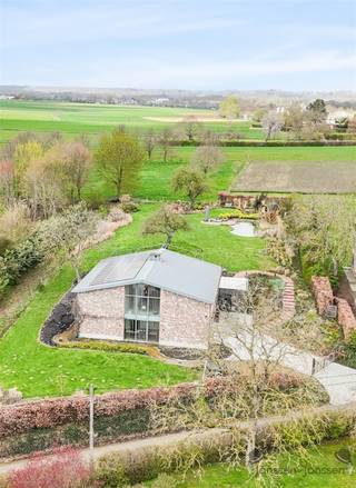 <p><span>Unieke landelijk-moderne villa met adembenemend uitzicht aan Troostembergbos</span></p><p><span> </span></p><p><span>Op een uitzonderlijk mooie locatie, aan de rand van het natuurgebied Troostembergbos, bevindt zich deze prachtige landelijk-moderne villa in nieuwstaat. Hier geniet je dagelijks van rust, natuur en een panoramisch uitzicht over de vallei en achterliggende velden.</span></p><p><span>De woning beschikt over 3 volwaardige slaapkamers en 2 stijlvolle badkamers, aangevuld met aparte dressingruimtes en een praktische bureelruimte ideaal voor thuiswerk met een inspirerend uitzicht.</span></p><p><span>Het absolute pronkstuk van deze villa is de indrukwekkende leefruimte van maar liefst 110 m² met loftallures. Dankzij de grote glaspartijen baadt deze ruimte in het natuurlijke licht en wordt binnen naadloos verbonden met buiten. Vanuit zowel de leefruimte als het bureel geniet je van een uniek zicht op de vallei en het omliggende natuurgebied.</span></p><p><span>De ligging is uitzonderlijk rustig: de enige geluiden die je hier hoort, zijn die van de natuur en het wild in het bos.</span></p><p><span>Daarnaast is deze woning bijzonder energiezuinig, uitgerust met een geothermische warmtepomp en zonnepanelen een duurzame investering in de toekomst.</span></p><p><span>Extra troef: een ruime schuur van 60 m² met dubbele poort, ideaal voor opslag, hobby of professioneel gebruik.</span></p><p><span> </span></p><p><span>Troeven op een rij:</span></p><ul><li><span>Uitzonderlijke ligging aan natuurgebied</span></li><li><span>Panoramisch uitzicht over vallei en velden</span></li><li><span>3 slaapkamers en 2 badkamers</span></li><li><span>Dressing en bureelruimte</span></li><li><span>Leefruimte van 110 m² met loftgevoel</span></li><li><span>Zwemvijver en sauna in de tuin</span></li><li><span>Energiezuinig (warmtepomp + zonnepanelen)</span></li><li><span>Schuur van 60 m² met dubbele poort</span></li><li><span>Absolute rust en privacy</span></li></ul><p><span>Een zeldzaam aanbod voor wie exclusief wil wonen in harmonie met de natuur.</span></p><p><span>Interesse? Neem gerust contact op voor meer informatie of een bezoek ter plaatse.</span></p>