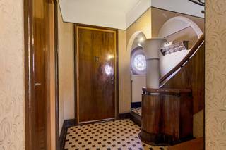 Deze art-deco woning (niet onderhevig aan renovatieplicht) is super centraal gelegen, midden in het centrum van het gezellige dorpje Zandvliet. De Botermarkt, winkels, openbaar vervoer en scholen zijn allen in de onmiddellijke omgeving te vinden. U betreedt de woning via de inkomhal die toegang geeft tot de bureau. Van daaruit loopt u door naar de woonkamer. Hier vindt u verschillende authentieke elementen terug, zoals de schouwen en ingebouwde kasten. Verder beschikt het gelijkvloers over een berging, eenvoudige keuken en compacte badkamer. De trap leidt u naar de eerste verdieping, waar u bovenkomt in de centrale nachthal met ingebouwde kast. Deze geeft toegang tot het balkon. Daarnaast heeft de eerste verdieping drie volwaardige slaapkamers, voorzien van rolluiken en elks met een eigen lavabootje. De zolder met twee velux-ramen is toegankelijk via een volwaardige trap. De mogelijkheid bestaat hier volwaardige slaapkamers te voorzien. Ook hier is een lavabo aanwezig. Enorme troef aan de woning is de ruime, zuidelijk georiënteerde tuin. Hier kan u in alle rust van de buitenlucht en het zonnetje genieten. Achteraan het perceel vinden we nog een dubbele garage die beschikt over twee automatische poorten.