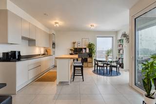 Op de zesde verdieping van De Faar, in de duurzame wijk De Nieuwe Dokken, bevindt zich dit luxueuze appartement met drie slaapkamers, twee badkamers en een prachtig uitzicht.<br /><br />De royale leefruimte omvat een ruime open keuken met plaats voor een volwaardige eetkamer en een aansluitende, gezellige televisiehoek. Van hieruit bereikt u het terras, met zijdelings uitzicht op het water en de drie torens van Gent: een bijzonder mooi stedelijk panorama.<br /><br />Het appartement beschikt over drie slaapkamers. De eerste badkamer is uitgerust met een ligbad en toilet; de tweede met een ruime inloopdouche. Daarnaast is er een afzonderlijk gastentoilet en een praktische, ruime berging. <br /><br />De Faar ligt aan het Handelsdok, tussen water en groen en op wandelafstand van de historische binnenstad. Via de Batavia- en Matadibrug bereikt u vlot het centrum. Ook station Gent-Dampoort en de Gentse ring zijn gemakkelijk bereikbaar.<br /><br />Een ondergrondse parkeerplaats kan worden bijgekocht voor € 30.000. Een extra ondergrondse berging is verkrijgbaar voor € 7.500, fietsenstalling is inbegrepen in de prijs.<br /><br />Een uitzonderlijk appartement voor wie ruimte, comfort, duurzaamheid en een uniek uitzicht wil combineren op een van de aantrekkelijkste woonlocaties van Gent.