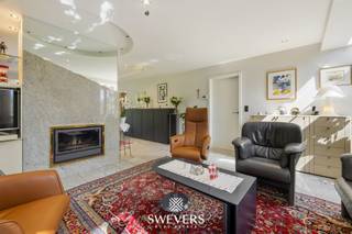 Voor meer info en foto’s, surf naar www.swevers.be – Deze ruime open bebouwing aan de Koerselsesteenweg 146 in Beringen combineert comfortabel wonen met professionele mogelijkheden. Dankzij aparte ingangen voor het privé- en praktijkgedeelte is de woning ideaal voor een zelfstandige activiteit aan huis, maar ook geschikt voor kangoeroewonen. De woning dateert van 1980 en werd doorheen de jaren gericht vernieuwd, met onder meer een nieuw pannendak, gerenoveerde living en keuken, vernieuwde condensatieketel, drie nieuwe Veluxramen en zonnepanelen uit 2023. Met een bewoonbare oppervlakte van 340 m² is er bijzonder veel ruimte. Op het gelijkvloers bevinden zich een woonkamer met eetkamer van samen 46 m², een keuken van 16,40 m², bureau en apart toilet. Het praktijkgedeelte omvat een wachtruimte, consultatieruimte, archief/doka en eigen toilet. Daarnaast zijn er een inpandige garage van 42 m² en een ruime berging. De eerste verdieping telt vier slaapkamers van 12,5 tot 22 m², waarvan één met terras en één met ingemaakte kasten. Verder zijn er een badkamer en apart toilet. De kelder van 44 m² zorgt voor extra bergruimte. Het perceel van 37a 75ca beschikt over een groen aangelegde tuin met meerdere terrassen en tuinhuisjes. Er is parkeerruimte voor 8 à 10 wagens. Scholen, openbaar vervoer en de snelweg zijn vlot bereikbaar. Extra troeven zijn het alarmsysteem, rolluiken, zonnewering en een beveiligde deur. Voor meer informatie, bel 011 255 155. Bron bewoonbare oppervlakte: EPC – verslag.
