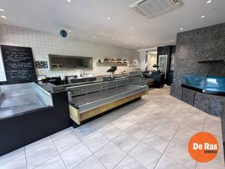 AALST - Handelspand met woonst op toplocatie<br /><br />Deze veelzijdige handelszaak met ruime woonst en uitgebreide opslagmogelijkheden is uitstekend gelegen vlak aan de Houtmarkt, in het centrum van Aalst. Dankzij de centrale ligging geniet het pand van een uitstekende bereikbaarheid en een sterke commerciële zichtbaarheid.<br /><br />Het handels gelijkvloers bevindt zich in een perfecte staat en omvat een moderne, recent ingerichte winkelruimte met een ruime toonbank, aangevuld met verschillende praktische werkruimtes, koelruimtes, bureauruimte en sanitair. Achteraan het perceel bevindt zich een ruime magazijn-/garageruimte met aansluitend een grote buitenparking, wat zorgt voor een optimale logistieke meerwaarde.<br /><br />De bovenliggende woonst biedt een aangename combinatie van comfort en ruimte en bestaat uit drie slaapkamers, een badkamer, een open keuken, een ruime leefruimte, een terras, kelder en een nog verder in te richten zolderverdieping met mezzanine.<br /><br />Met een totale oppervlakte van maar liefst ca. 400 m² biedt dit pand een uitzonderlijk potentieel voor ondernemers, zelfstandigen of investeerders. De combinatie van commerciële ruimte, opslagmogelijkheden en een ruime woning maakt dit een uniek aanbod met tal van gebruiksmogelijkheden in het hart van Aalst.<br /><br />Voor meer informatie of een bezoek, kan u ons steeds contacteren: 053/60.65.60.
