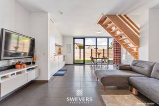 Voor meer info en foto’s, surf naar www.swevers.be – Instapklare halfopen woning op een rustige locatie in Beverlo, gelegen in een doodlopende straat vlak bij een parkje met speeltuin. Deze verzorgde gezinswoning werd gebouwd in 2015 en biedt een bewoonbare oppervlakte van 111 m². In 2025 werd bovendien een laadpaal geplaatst, wat extra comfort biedt voor wie elektrisch rijdt. Bij het binnenkomen betreedt u de inkomhal met gastentoilet. De woonkamer van 17,52 m² is aangenaam en praktisch in te richten met een zithoek. Aansluitend vindt u de ruime keuken en eethoek van 19,51 m², met voldoende plaats voor een functionele opstelling. Vanuit de keuken heeft u rechtstreeks toegang tot het terras. Verder is er een handige berging met aansluiting voor wasmachine en technische voorzieningen.<br />Op de verdieping zijn er drie slaapkamers van 13,44 m², 8,01 m² en 5,76 m², ideaal als slaapkamer, bureau of dressing. De badkamer is centraal gelegen en functioneel ingericht. Buiten geniet u van een compact en onderhoudsvriendelijk perceel van 1a 69ca met noordoostelijke oriëntatie, ideaal voor ochtend- en voormiddagzon op het terras. Extra troeven zijn de carport van 17,1 m², extra bergruimte, een tuinhuisje, rolluiken in de slaapkamers, vliegenramen en een beveiligde deur. Winkels, scholen, openbaar vervoer en ontspanning bevinden zich in de nabije omgeving, met een vlotte verbinding naar de snelweg. Voor meer informatie, bel 011 255 155. Bron bewoonbare oppervlakte: EPC – verslag.