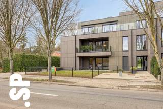 Prachtig gelegen en instapklaar hoekappartement van 94 m² met twee slaapkamers en een privaat tuintje met terras.<br /><br />Dit lichtrijke appartement verwelkomt je via een verzorgde inkomhal met vestiairekast en gastentoilet. Van hieruit kom je in de ruime leefruimte, waar de grote raampartijen zorgen voor een aangename lichtinval en een open, luchtig gevoel. De leefruimte sluit naadloos aan op de volledig uitgeruste keuken (10,2 m²), voorzien van kasten, dampkap, keramisch kookvuur, combi-oven, koelkast, vaatwasser en spoelbak. Vanuit de leefruimte (24,2 m²) heb je directe toegang tot het private tuintje met terras.<br /><br />Via de nachthal bereik je de twee slaapkamers (14,3 m² en 8,9 m²) en de moderne badkamer, uitgerust met een lavabomeubel en comfortabele inloopdouche.<br /><br />Daarnaast beschikt het appartement over een ondergrondse autostaanplaats, inbegrepen in de verkoopprijs, evenals een gemeenschappelijke fietsenstalling en een grote gemeenschappelijke tuin achteraan het gebouw. Alsook is er een lift aanwezig in het gebouw.<br /><br />Op vlak van comfort en energiezuinigheid scoort dit appartement bijzonder goed. De verwarming gebeurt via aardgas met vloerverwarming. Zonnepanelen zijn aanwezig, evenals automatische screens voor zonwering. Met een EPC-label A+ geniet je hier van een uiterst energiezuinige woonst.<br /><br />Kortom, een modern en energiezuinig hoekappartement dat comfort, licht en een aangename buitenruimte perfect combineert.<br /><br />Voor meer informatie of een bezoek ter plaatse, kan u contact opnemen met IMMO SP via 014 59 10 20 of mailen naar jill@immosp.be. Benieuwd naar de waarde van uw eigen woning? Vraag vrijblijvend een gratis verkoopanalyse aan – wij helpen u graag verder!