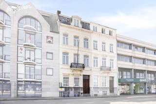 - Herenhuis met grandeur: veel authentieke elementen en hoge plafonds<br />- Topligging in Kortrijk-centrum: Minister Tacklaan 39<br />- Ruime inkomhal met apart toilet<br />- Lichtrijke leefruimte met zithoek en eetplaats<br />- Praktische keuken<br />- Bureau <br />- Toffe, zuidgerichte stadstuin met terras en tuinhuis<br />- 2 slaapkamers op de eerste verdieping, waarvan 1 met wastafel<br />- Badkamer met douchebad en wastafel<br />- 3 slaapkamers op de tweede verdieping, waarvan 2 met wastafel<br />- Ruime, open zolder met mogelijkheid tot 2 extra slaapkamers<br />- Woning is volledig onderkelderd (volwaardige, droge kelder)<br />- Ondergrondse garage in het gebouw ernaast inbegrepen<br />- EPC: 237 kWh/m²/jaar, label C (geen renovatieplicht) UC: 3535811<br />- Overal centrale verwarming<br />- Asbestveilig<br />- Regenwaterput <br />- Richtprijs: € 469.000