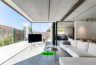 Deze moderne villa bevindt zich in de Snoekstraat, een doodlopende straat in een rustige en kindvriendelijke woonwijk te Vlissegem. Het strakke architecturale ontwerp, de overvloedige lichtinval en het open zicht op de omgeving zorgen voor een harmonieuze combinatie van comfort en hedendaagse elegantie.<br /><br />Via de inkomhal met gastentoilet kom je in de ruime leefruimte met grote keramische vloertegels. Woon- en eetgedeelte vloeien naadloos in elkaar over en vormen samen een gezellige, open ruimte. De moderne keuken — uitgevoerd in verfijnd houten maatwerk met een travertin marmeren werkblad en ingebouwde Miele-steamer — vormt het centrale punt van de woning. De aluminium ramen met glas-op-glas hoeken versterken het gevoel van openheid en zorgen voor een open blik op de zuidgerichte tuin met terras, een ideale plek om te genieten van rust en zon.<br /><br />Aansluitend vind je een koele berging, een ruime wasplaats met veel opbergruimte en een aparte bureauruimte, ideaal voor wie een rustige plek zoekt voor administratie of studie.<br /><br />Op de verdieping bevinden zich vier volwaardige slaapkamers, een dressing en een stijlvolle badkamer met inloopdouche, dubbele wastafel en badmogelijkheid. De nachthal biedt extra bergruimte en toegang tot een afzonderlijk toilet.<br /><br />Met een E-peil van 14 combineert de woning modern wooncomfort met optimale energie-efficiëntie. 15 zonnepanelen, vloerverwarming en een regenwaterput van 15.000 liter dragen bij aan een duurzaam en laag-verbruik leefklimaat. De oprit voor twee wagens maakt de praktische kant van de woning compleet.<br /><br />De bewoonbare oppervlakte stemt overeen met de nuttige oppervlakte zoals gekend bij het kadaster.<br /><br />Bent u op zoek naar een woning die rust, ruimte en comfort biedt? Neem dan snel contact op met Julien via julien@immofrancois.be of bel +32 471 74 25 41. <br /><br />