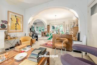 Maak kennis met deze karaktervolle doch op te frissen villa van 1939 ontworpen door architect H. Verbruggen, opgebouwd in de interbellumstijl, en gelegen op een ruim perceel aan de rand van een gegeerde villawijk in Sint-Kruis vlakbij scholen, winkels, station, ziekenhuis, centrum Brugge, ontspaningsmogelijkheden,... <br />De unieke en authentieke uitstraling van de villa gecombineerd met de groene omgeving maakt deze woonst dan ook erg bijzonder. <br /><br />De villa werd door de huidige eigenaars in 1990 uitgebreid tot een woning met praktijkgedeelte (die perfect kan dienen als bureel of kangoeroewoning). Dit praktijk/kangoeroegedeelte heeft een afzonderlijke praktische ingang. <br />De hoofdwoning dient op bepaalde aspecten wel terug gemoderniseerd te worden om terug aan het hedendaags wooncomfort te kunnen voldoen. <br /><br />De villa betreden we via een statige en ruime inkomhal met authentieke trap. Verder begeven we ons naar de riante leefruimte opgesplitst in verschillende zithoeken die van elkaar afgescheiden zijn via authentieke boogstructuren, een naastgelegen afzonderlijke eetplaats en keuken. <br />Voorts vinden we op de gelijkvloerse verdieping nog een doorgang terug naar het bijgebouwde praktijk/bureelgedeelte. Daar vinden we nog een apart toilet terug, kitchenette, douchekamer en een leefruimte/bureelruimte of ruimte die kan dienen als extra leefruimte/kangoeroewoning. <br /><br />Op de eerste verdieping vinden we 4 slaapkamers terug (waarvan masterbedroom met annex dressing/bureau) en een badkamer. <br />Op de tweede (zolder)verdieping vinden we nog een 5e slaapkamer of polyvalente kamer terug die te bereiken is via een vaste trap. <br /><br />Deze villa beschikt naast de riante achtertuin tevens over een mooi aangelegde voortuin met afzonderlijke toegang tot het praktijk/bureelgedeelte, alsook een parking voor wagens en oprit naar achteren met carport.<br /><br />Kortom: een zeldzame en ruime villa gelegen op een uiterst gegeerde en strategische locatie. Contacteer ons snel voor een bezoek aan dit eigendom via info@delbecque.immo of 050 45 03 45